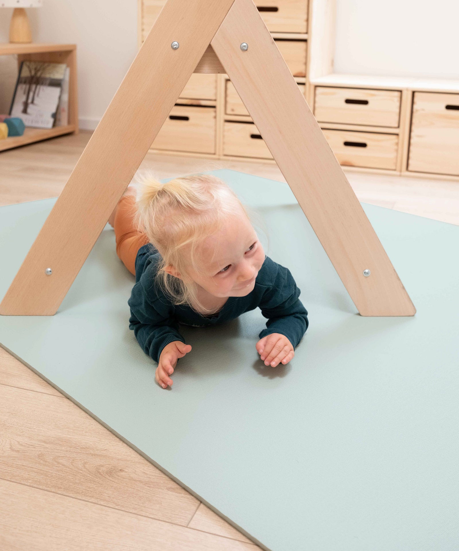 Kind spielt auf der Krabbelmatte.