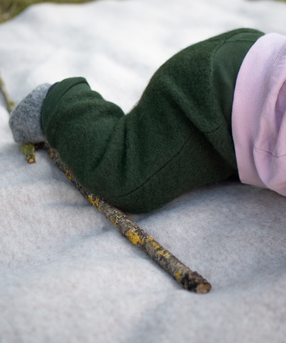 Baby krabbelt auf einer Decke.