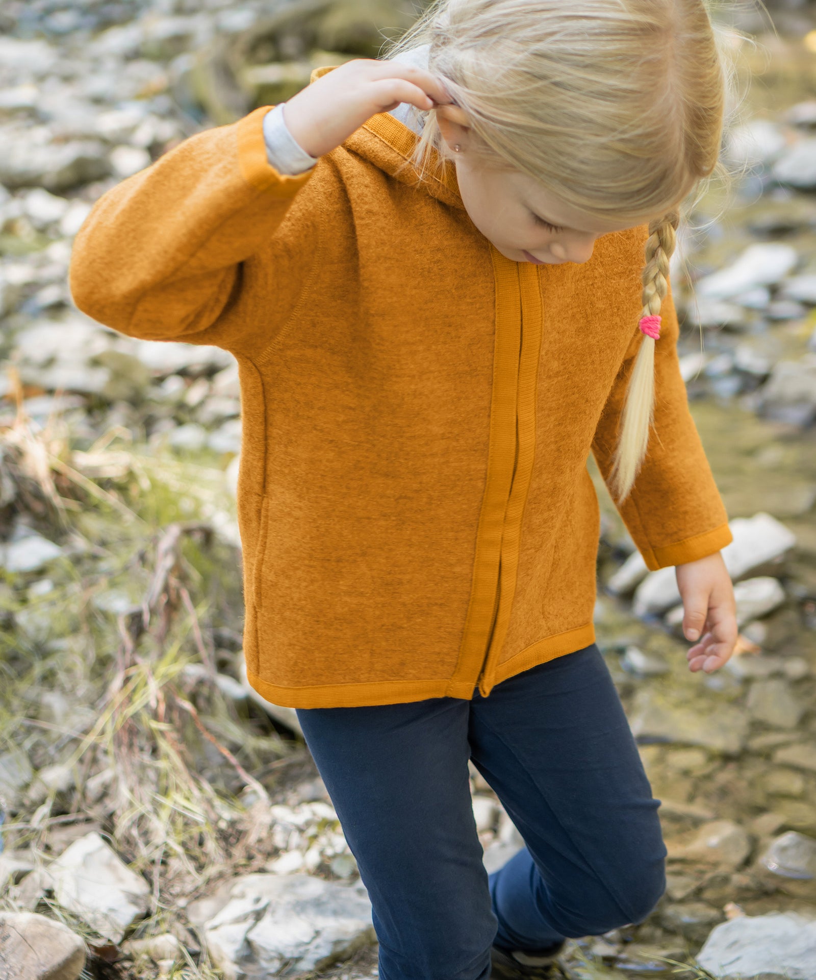 Perfekt für kühle Tage*Mit unserer Walkjacke ist dein Kind perfekt gerüstet für den Spielplatz, Waldspaziergänge und Outdoor-Abenteuer.|Mädchen mit Walkjacke in safrangelb an einem Bach.