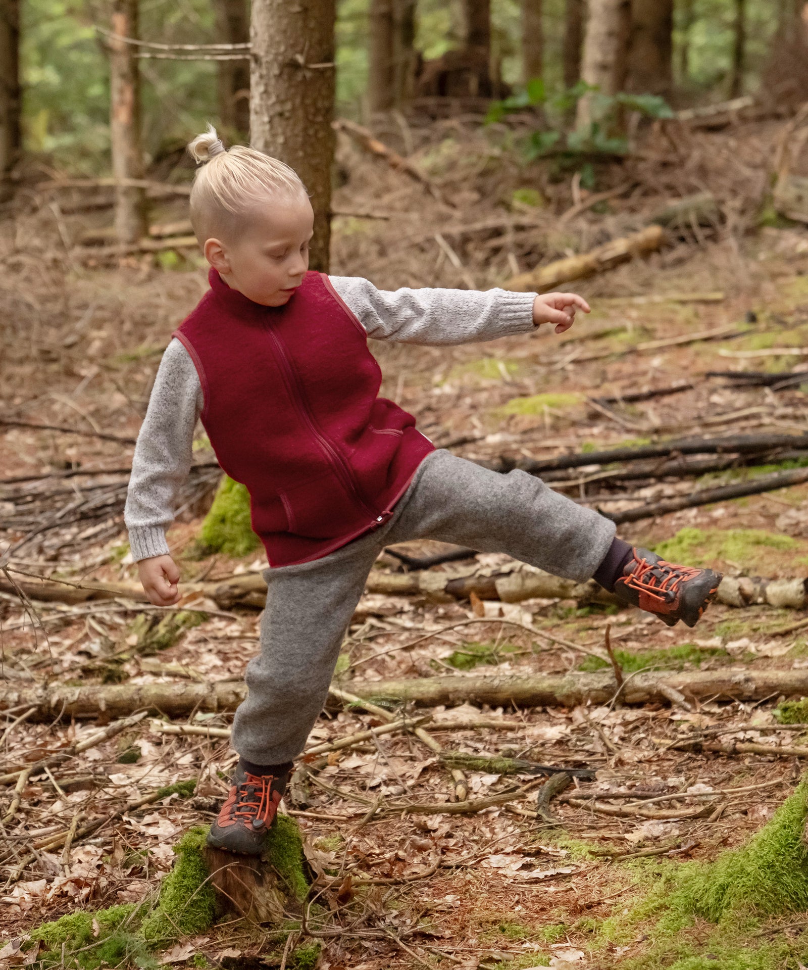 Kind springt im Wald.