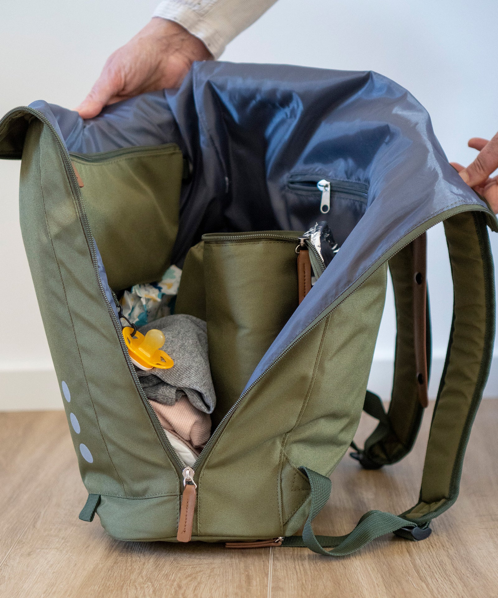 Für alles einen Platz*Ein herausnehmbares Etui für kleine Utensilien wie Schnuller, eine abwischbare Wickelunterlage und ein isolierter Flaschenhalter.|Blick in gefüllten Wickelrucksack.