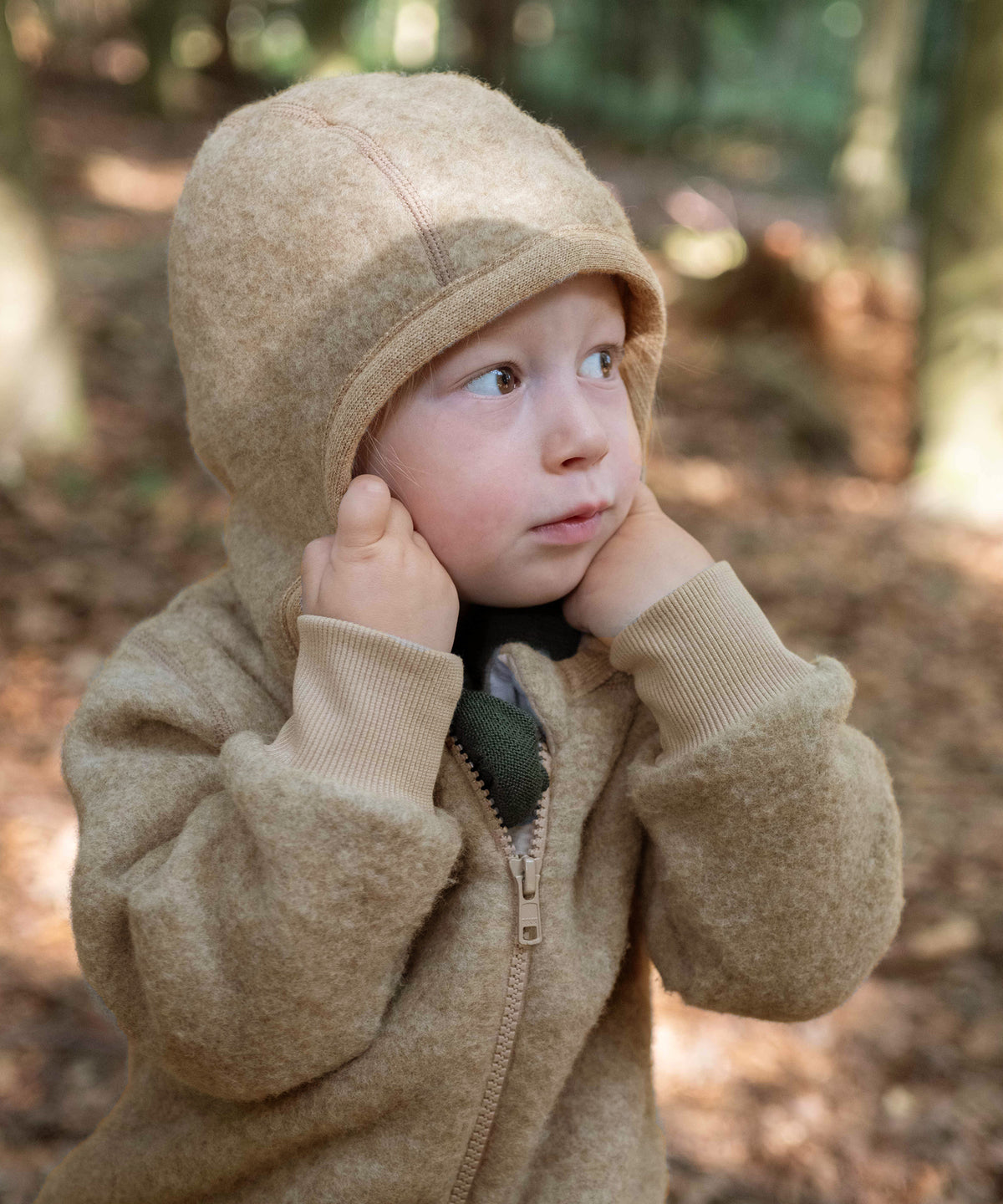 Mädchen zieht Kapuze des Wollfleece-Overalls auf.