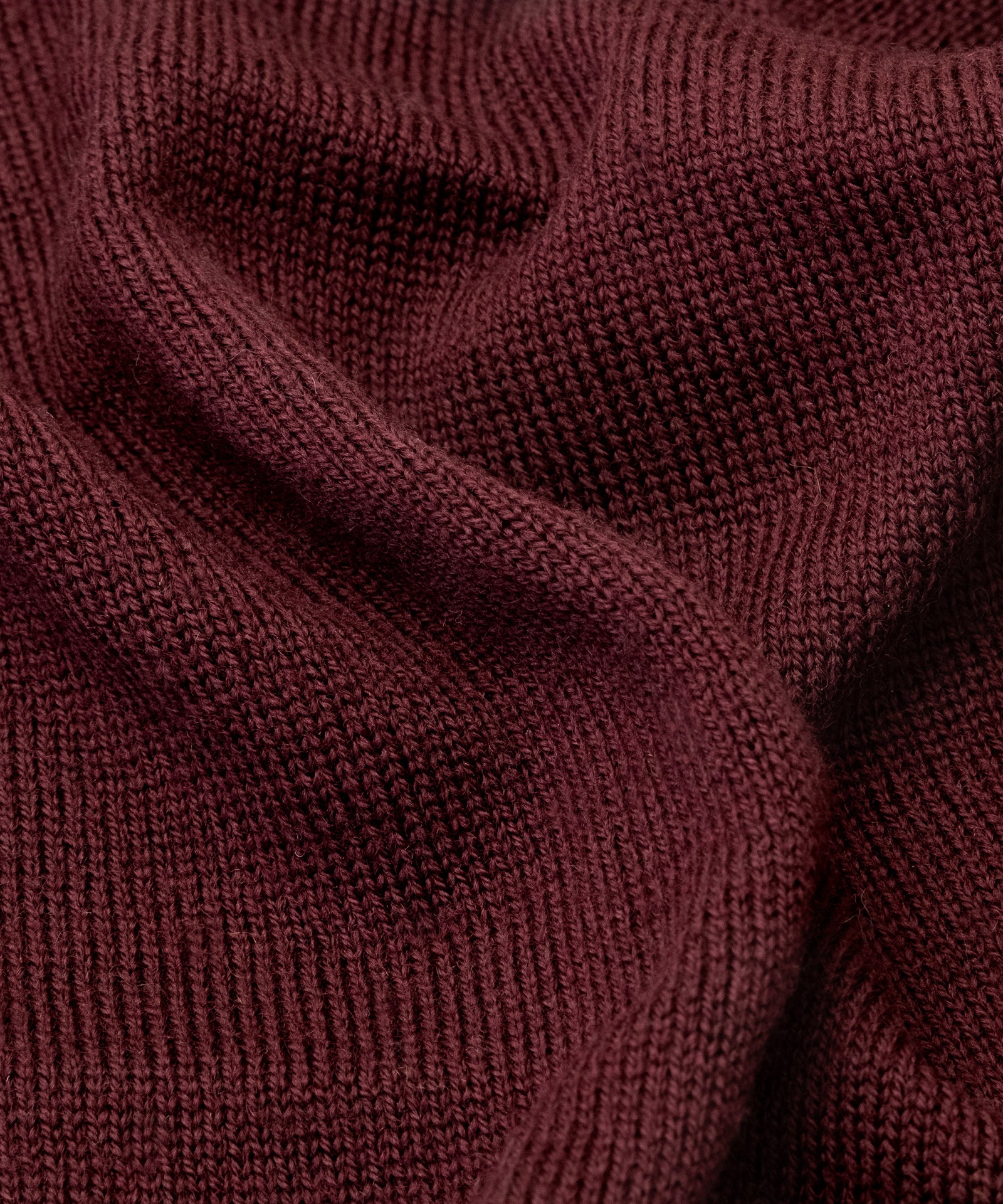 Atmungsaktiv & wärmend*Merinofasern sind aufgrund ihrer natürlichen Eigenschaften atmungsaktiv und helfen so, die Körpertemperatur zu regulieren.|Nahaufnahme gestrickter Schlauchschal in Bordeaux.