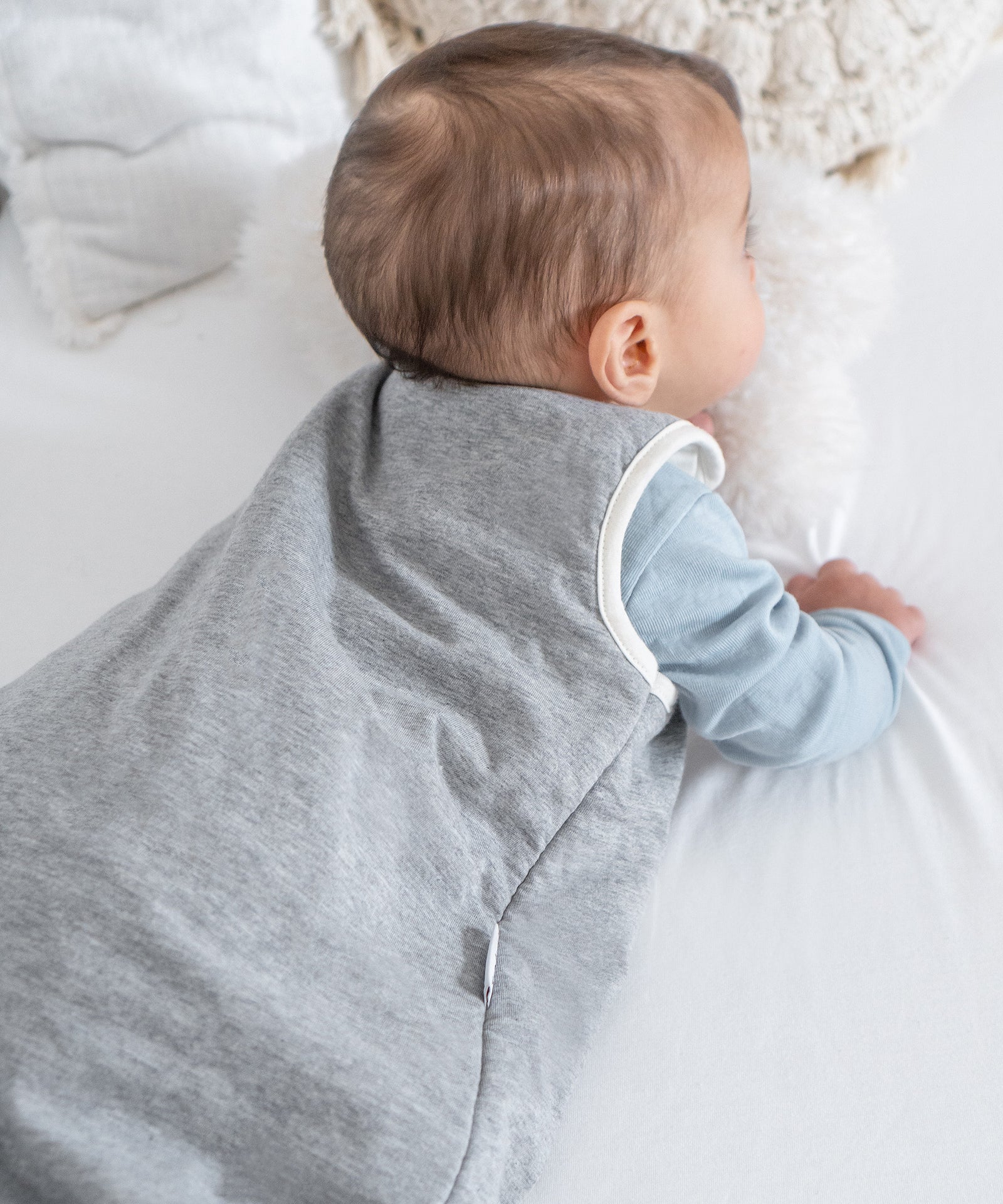 Baby in grauem Schlafsack.