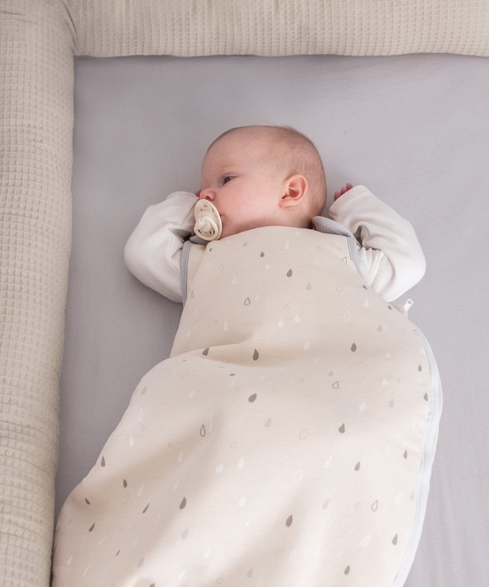 Baby liegt ruhig im leichten Sommerschlafsack für angenehme Nächte