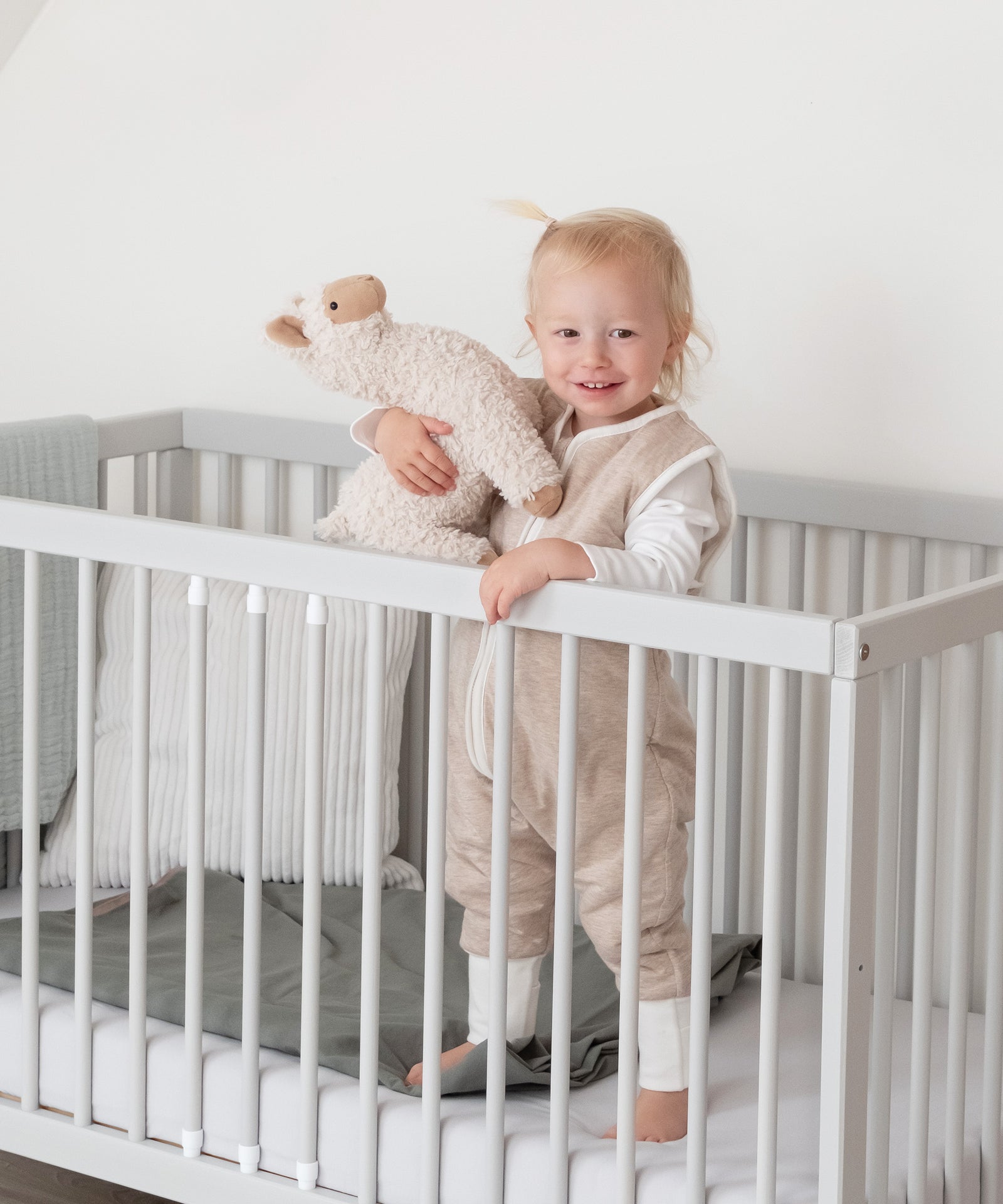 Kind trägt einen Schlafsack mit Beinen und Wollfüllung in Beige und bewegt sich frei.