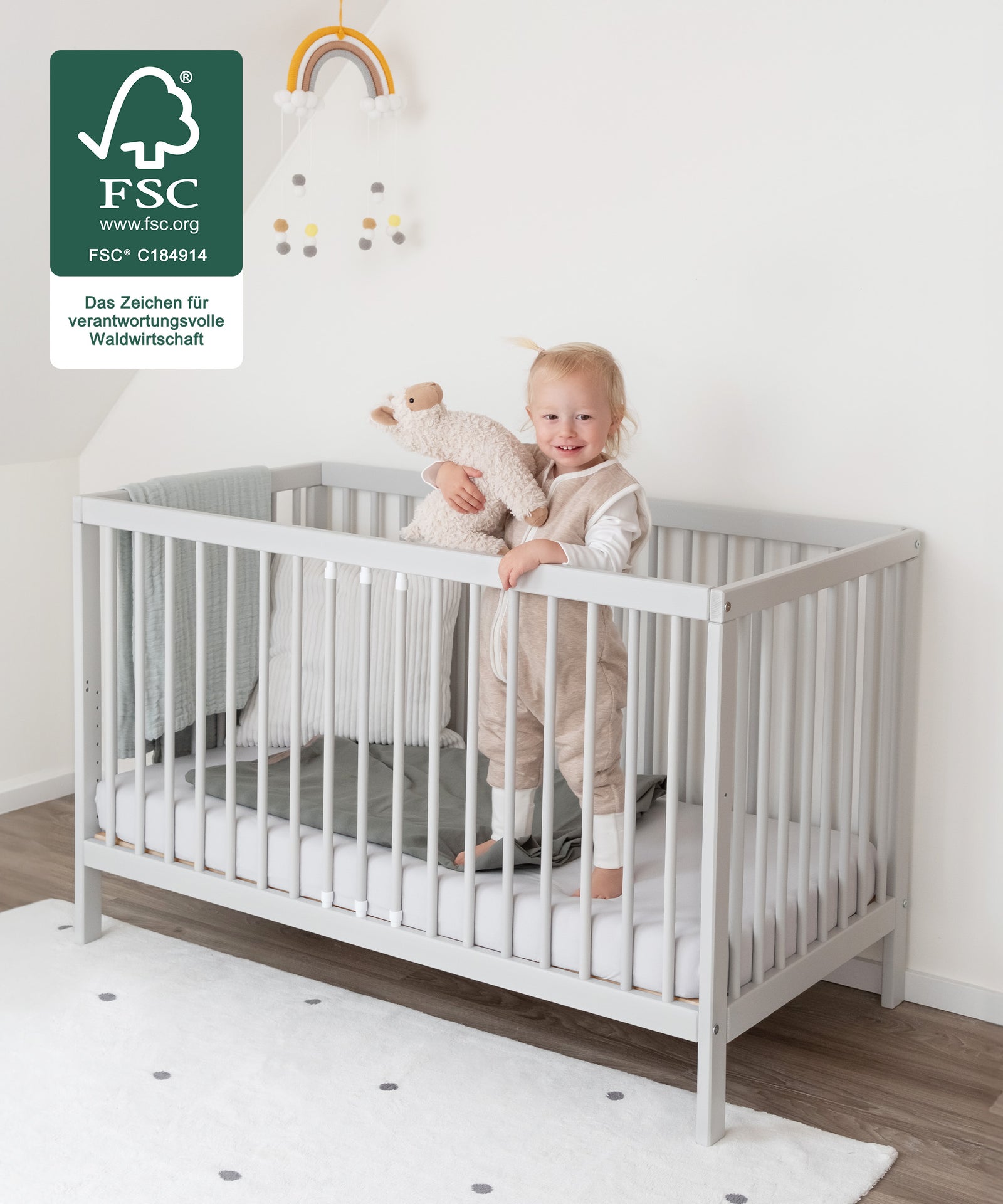 Robust & Kindgerecht*Das Bett bietet deinem Kind Geborgenheit beim
Spielen und Schlafen.|Kind steht im Babybett.