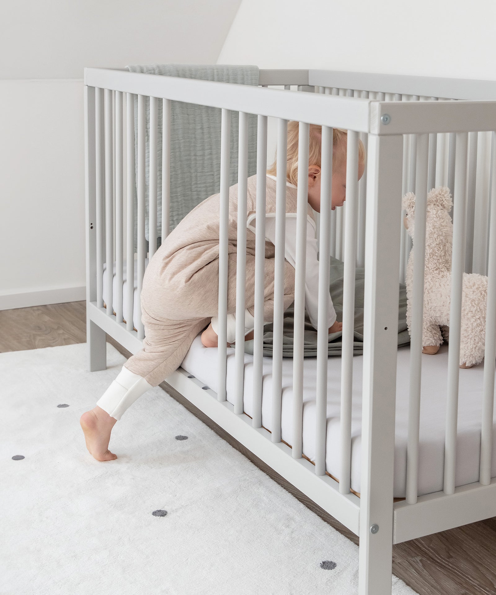 Fördert die Selbstständigkeit*Durch die herausnehmbaren Stangen kann dein Kind ganz alleine ein- und aussteigen. Der Rausfallschutz bleibt dabei erhalten.|Kind steigt selbstständig auf das Babybett.