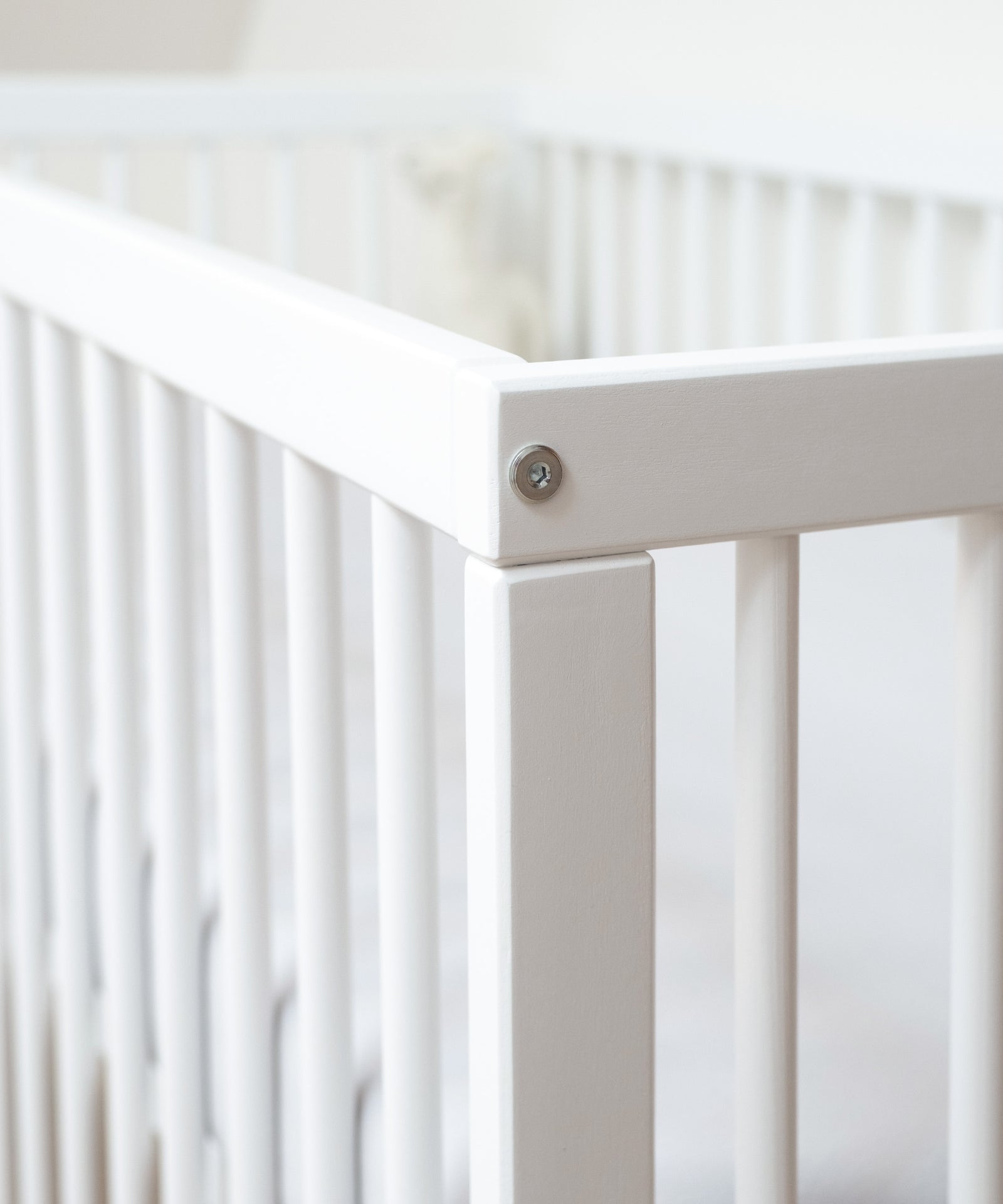 Hochwertige Materialien & FSC®-zertifiziert*Das Gitterbett wird aus massivem Buchenholz gefertigt und ausschließlich mit kinderfreundlichen Lacken behandelt.|Nahaufnahme Babybett weiß.