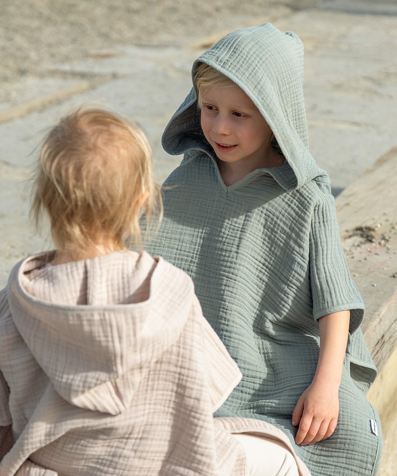 Kinder im Badeponcho mit Kapuze.