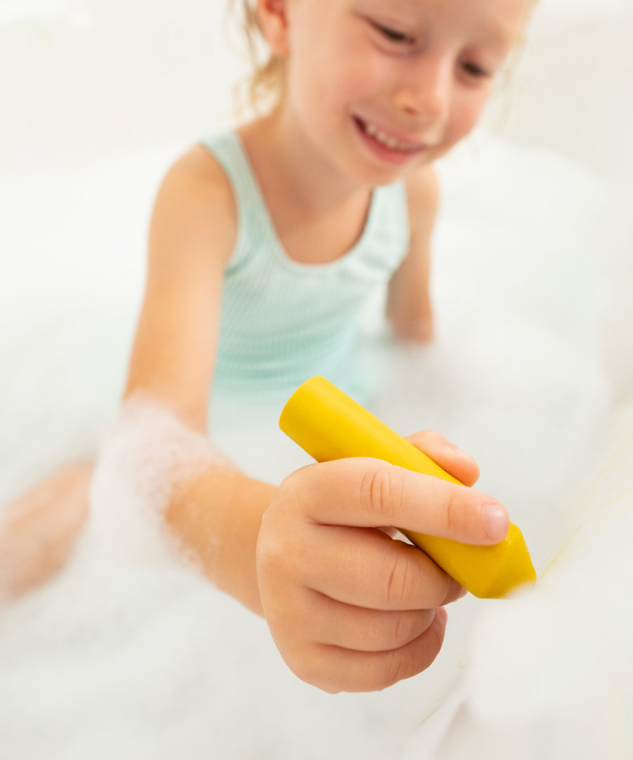 Natürlich & kindgerecht*Die Badewannenstifte bestehen aus 100 % natürlichem Bienenwachs und sorgen für unbeschwerten Malspaß in der Badewanne.|Kind spielt mit dem Stift in der Badewanne.