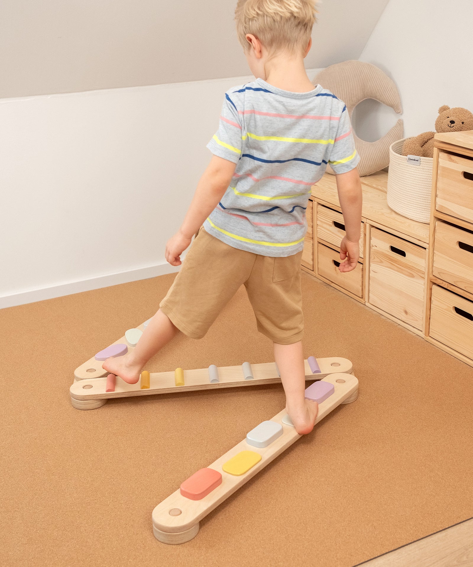 Kind trainiert Gleichgewicht auf Balancierbalken von Ehrenkind.