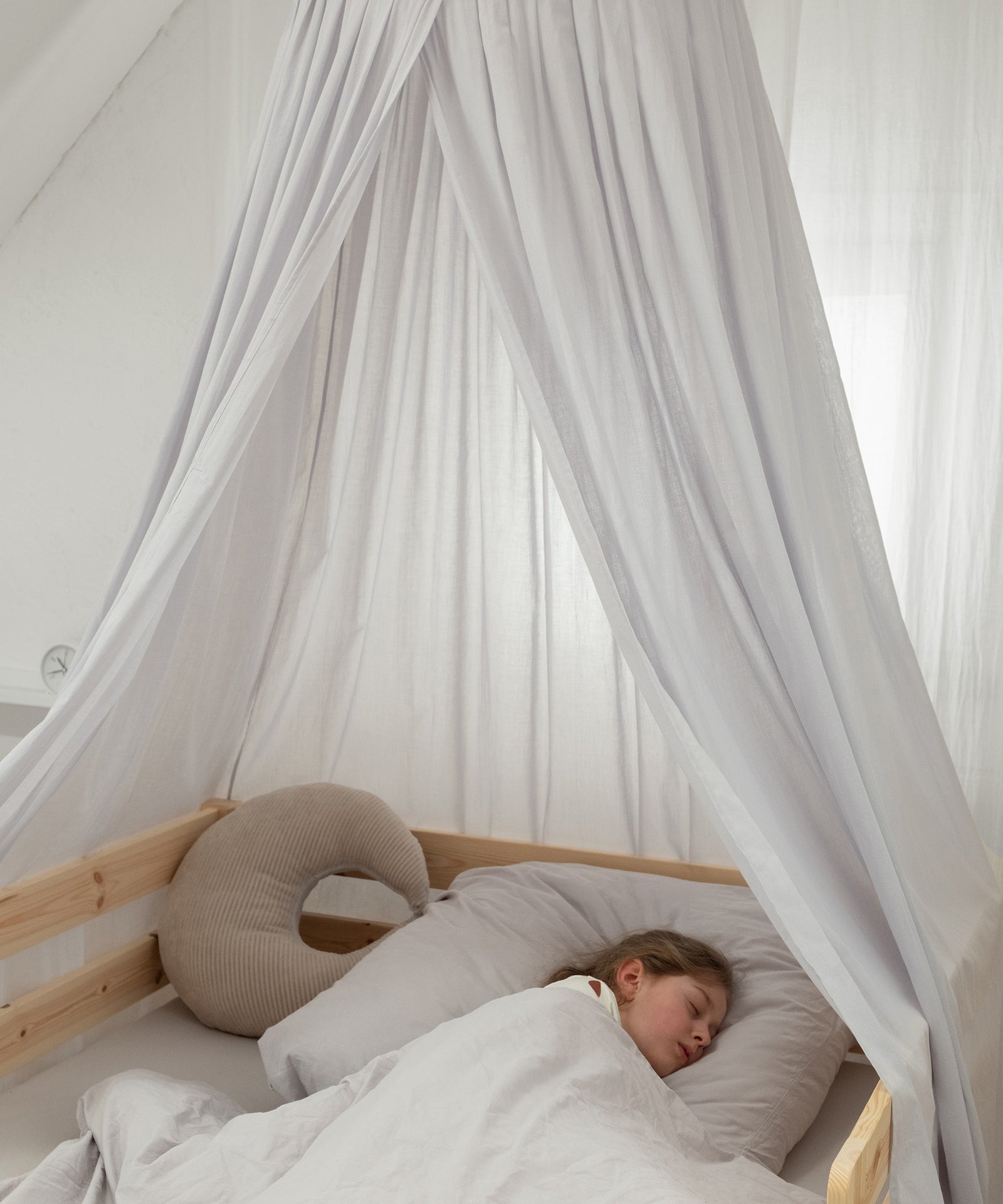 Schlafplatz mit grauem Baldachin als Himmel für das Kinderbett.