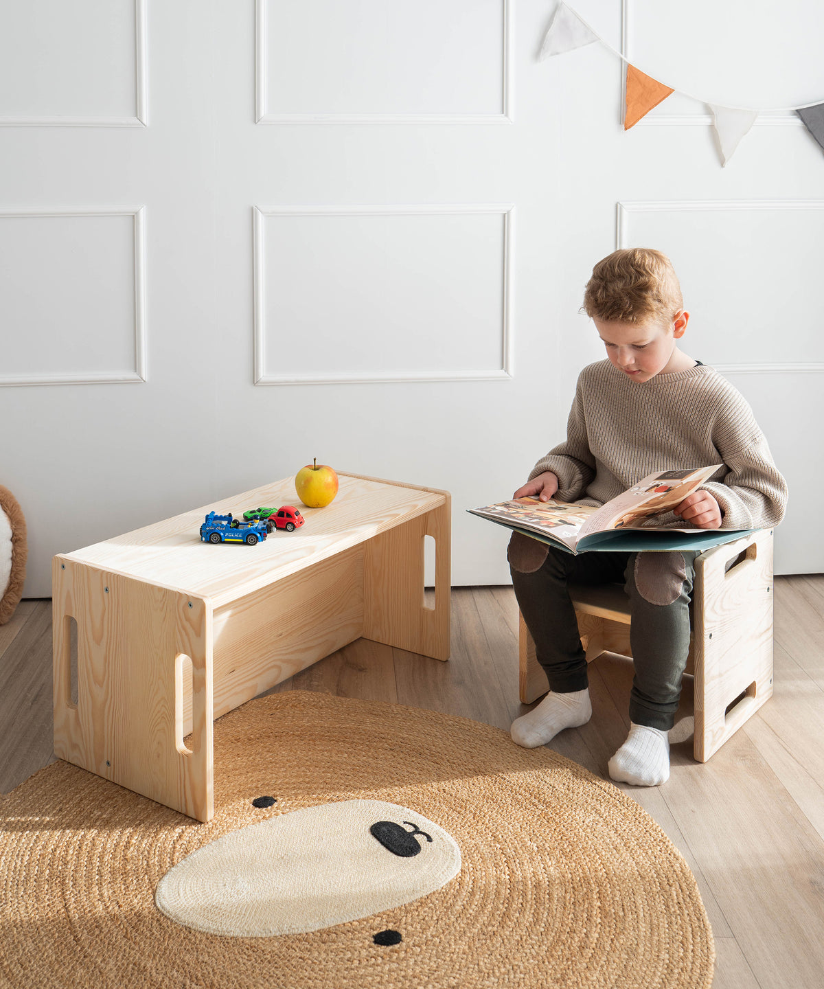 Flexibel & alltagstauglich*Ob Essen, Spielen oder Lesen - Bank und Hocker passen sich dem Alltag deines Kindes an und bieten vielseitige Einsatzmöglichkeiten.|Kind liest Buch auf Hocker und nutzt Bank als Tisch.