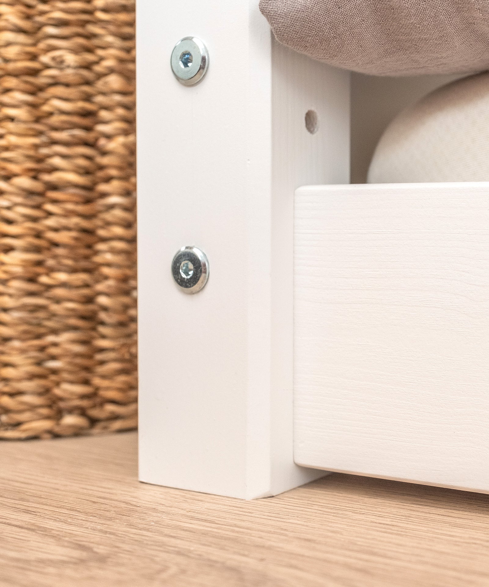 Nahaufnahme weiß lackiertes Kiefernholtz bodentiefes Bett.