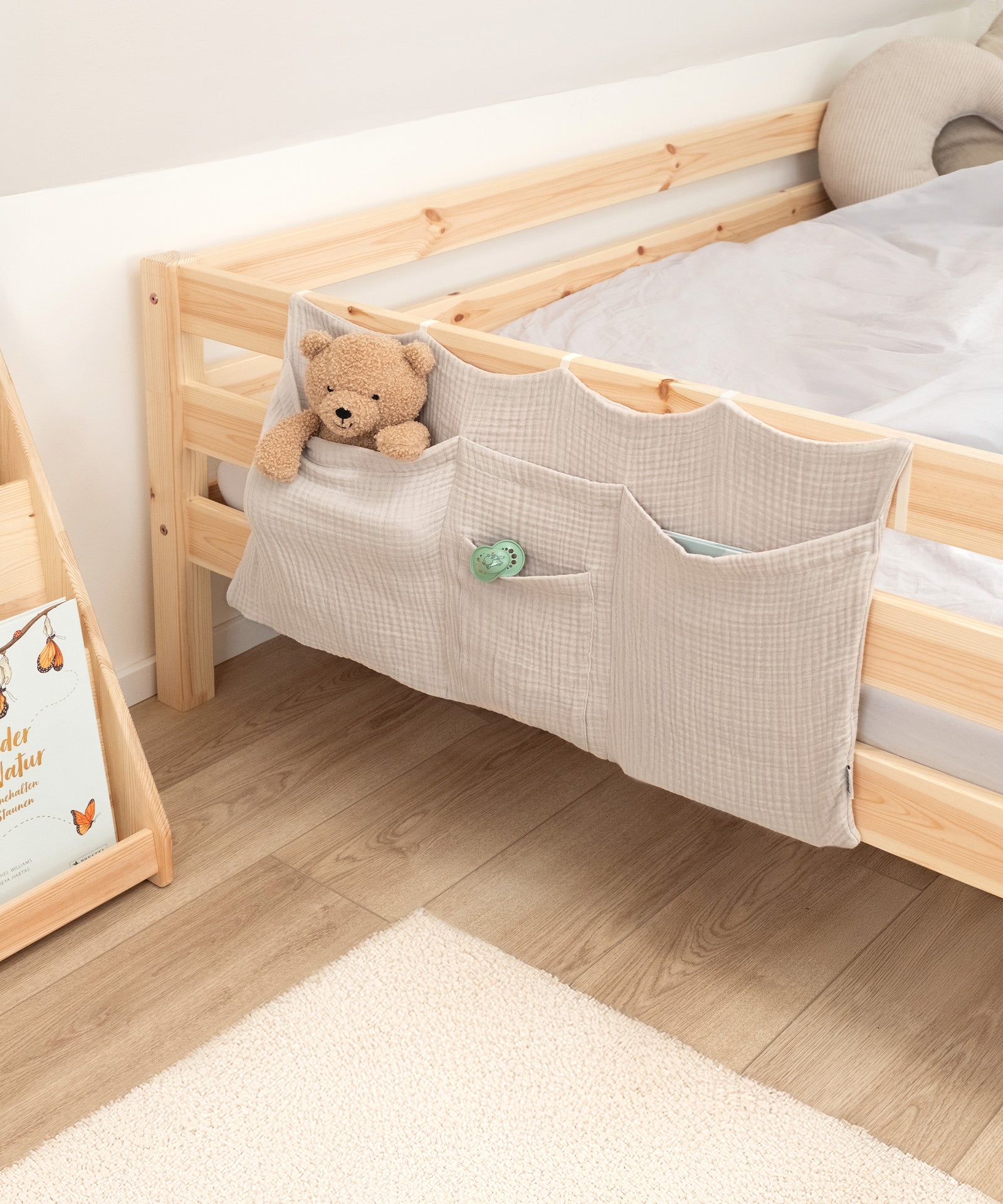 Ordnung mit Stil*Der Bett Organizer ergänzt das Kinderzimmer mit vier Fächern und sanften Farben - praktisch und optisch ein echtes Highlight.|Bett Organizer in Beige am Kinderbett mit Kuscheltier und Schnuller in den Taschen.