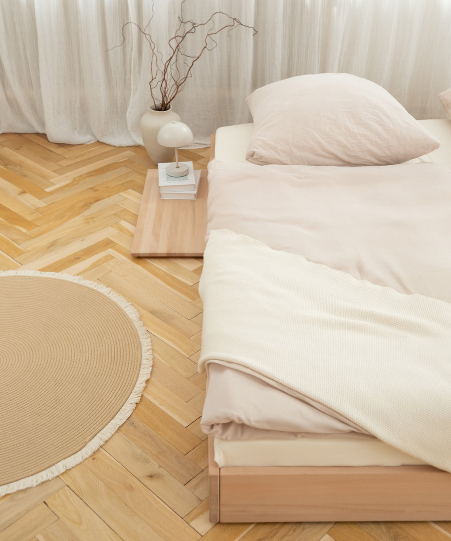 Bodenbett Plano Buche mit Ablage auf dem Boden.