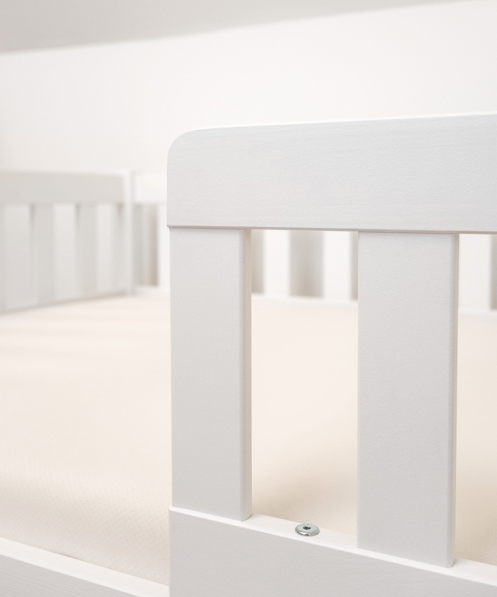 Nachhaltiges Kiefernholz*Unser Bodenbett wird aus nachhaltigem Kiefernholz unter fairen Arbeitsbedingungen gefertigt.|Nahaufnahme Kiefernholz weiß lackiert.