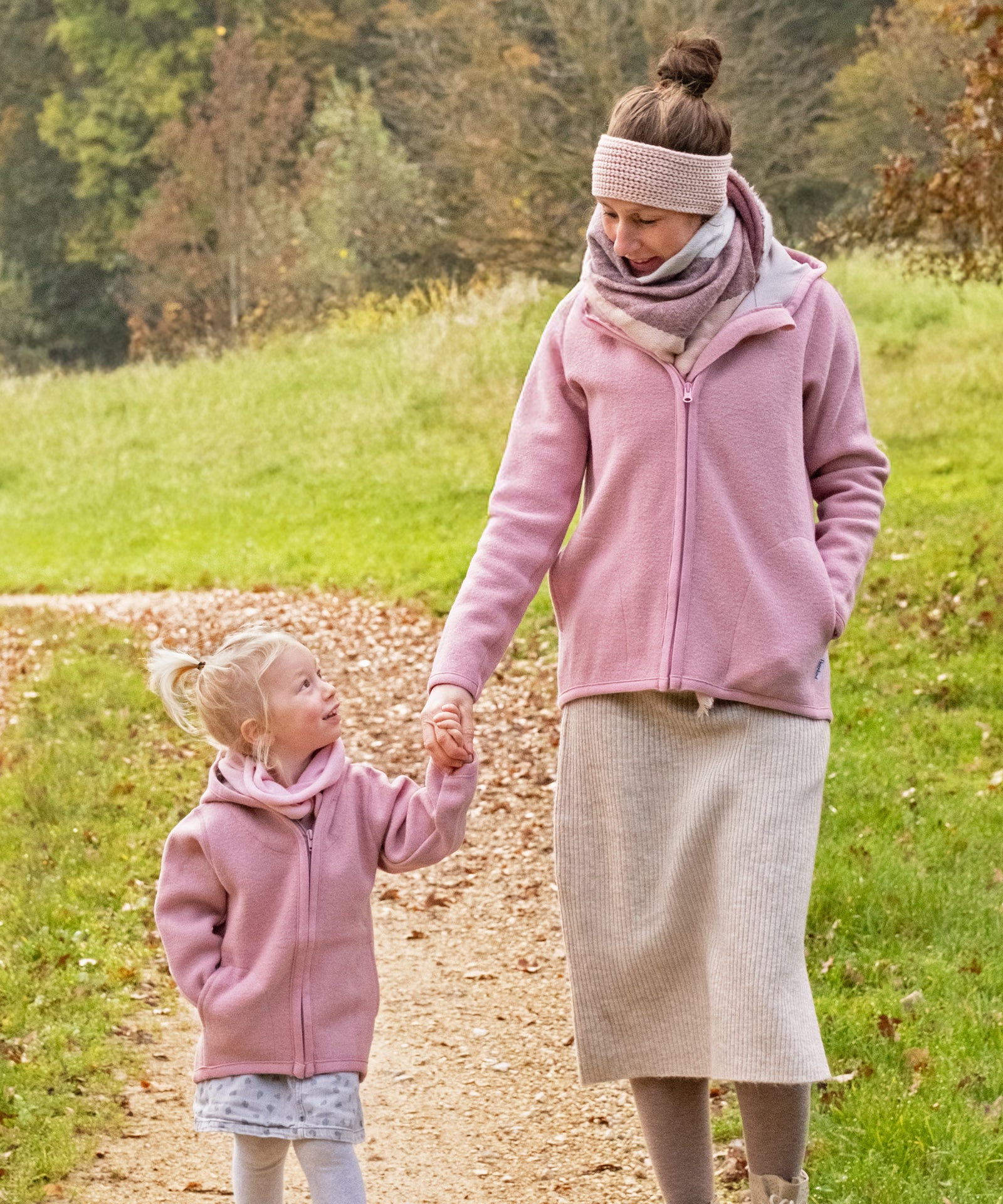 Perfekt für kühle Tage*Unsere bequem geschnittene Walkjacke für Damen ist der ideale Alltagsbegleiter für alle Outdoor-Aktivitäten als Familie.|Frau in Walkjacke Damen Altrosa geht mit Mädchen mit Kinder-Walkjacke Altrosa