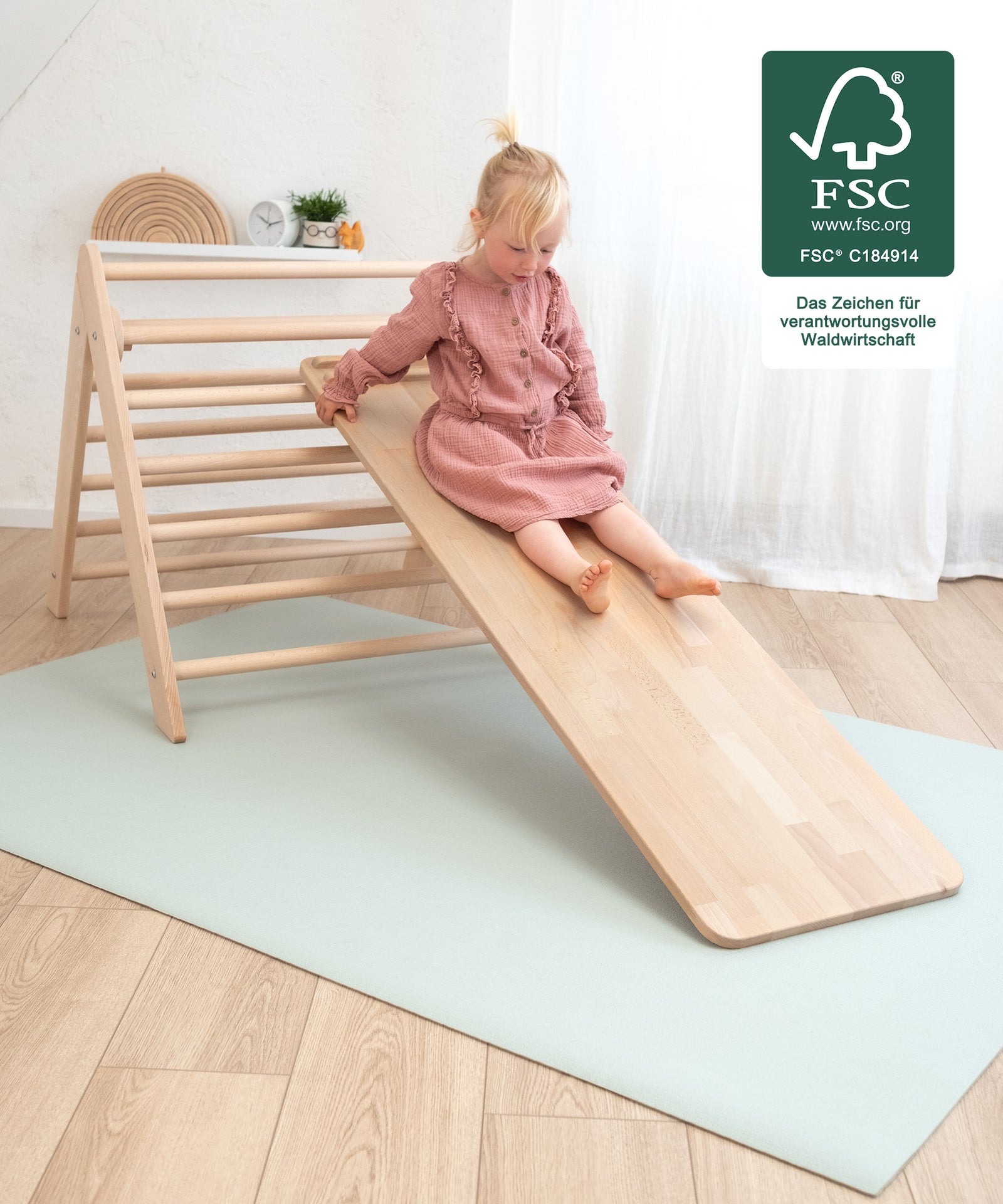 Garantierter Rutschspaß*Die Vorderseite des Rutschbretts besitzt eine glatte Oberfläche, auf der dein Kind nach Herzenslust rutschen kann.|Kind rutscht auf dem Rutschbrett runter.