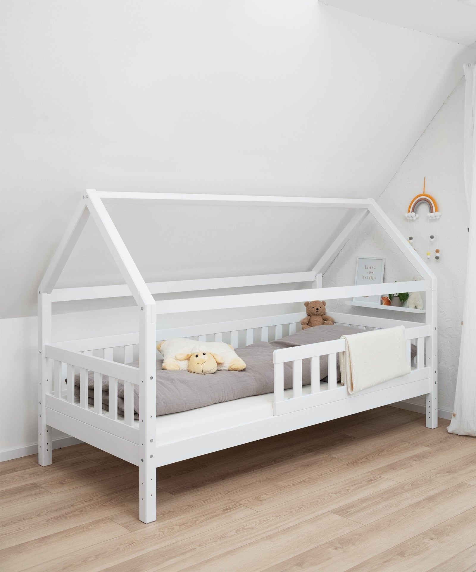 Hausbett Kiefer weiß mit vorne montiertem Balken.