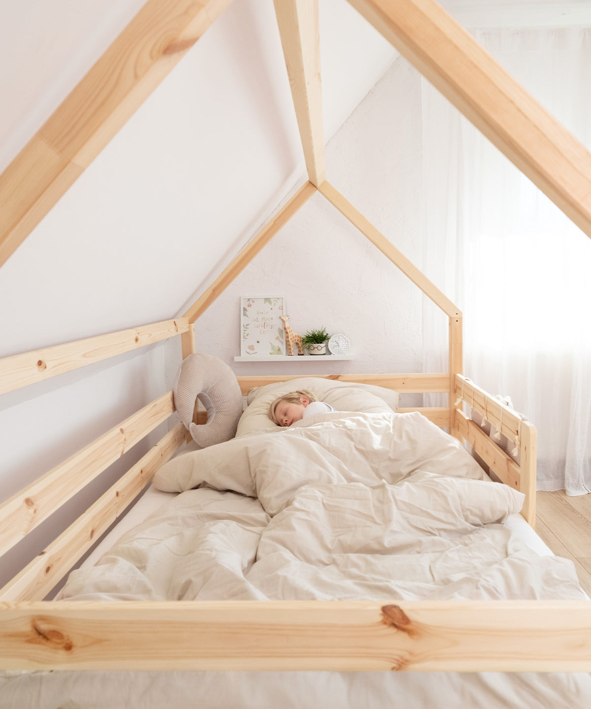 Kind schläft in dem Hausbett.
