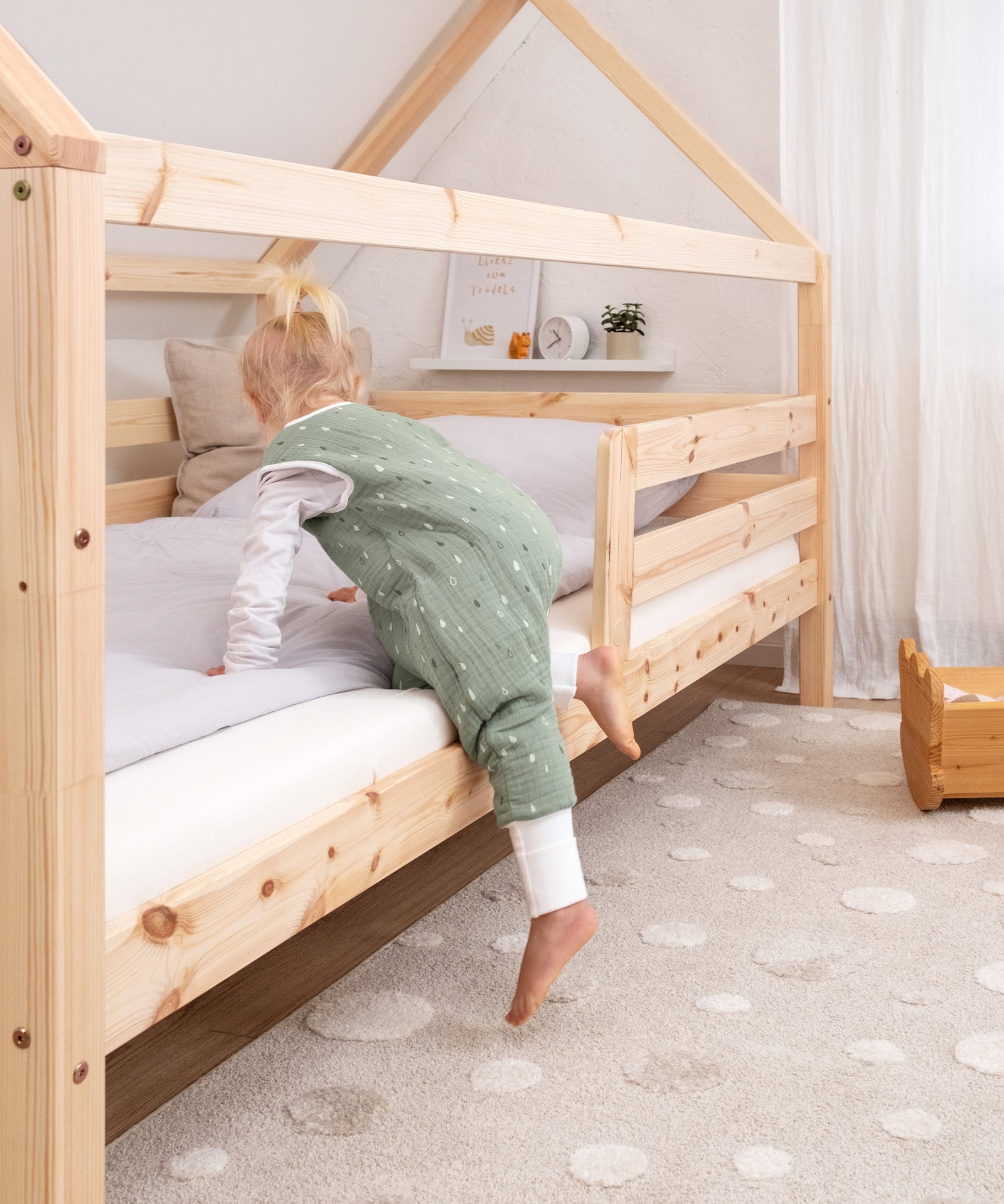 Kind steigt alleine in das Hausbett Sona Natur.