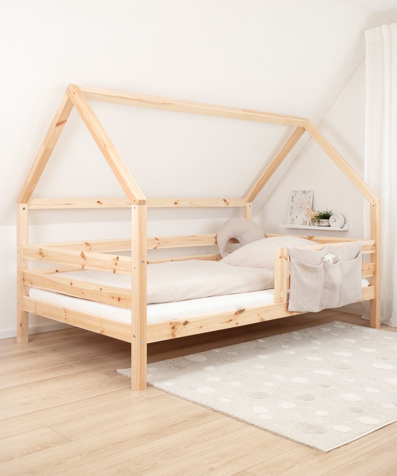 Mehr als nur ein Schlafplatz*Das kindgerechte Bett im zeitlosen Design ist ein gemütlicher Rückzugsort für dein Kind - perfekt zum Lesen, Spielen und Kuscheln.|Das Hausbett steht aufgebaut an der Wand.