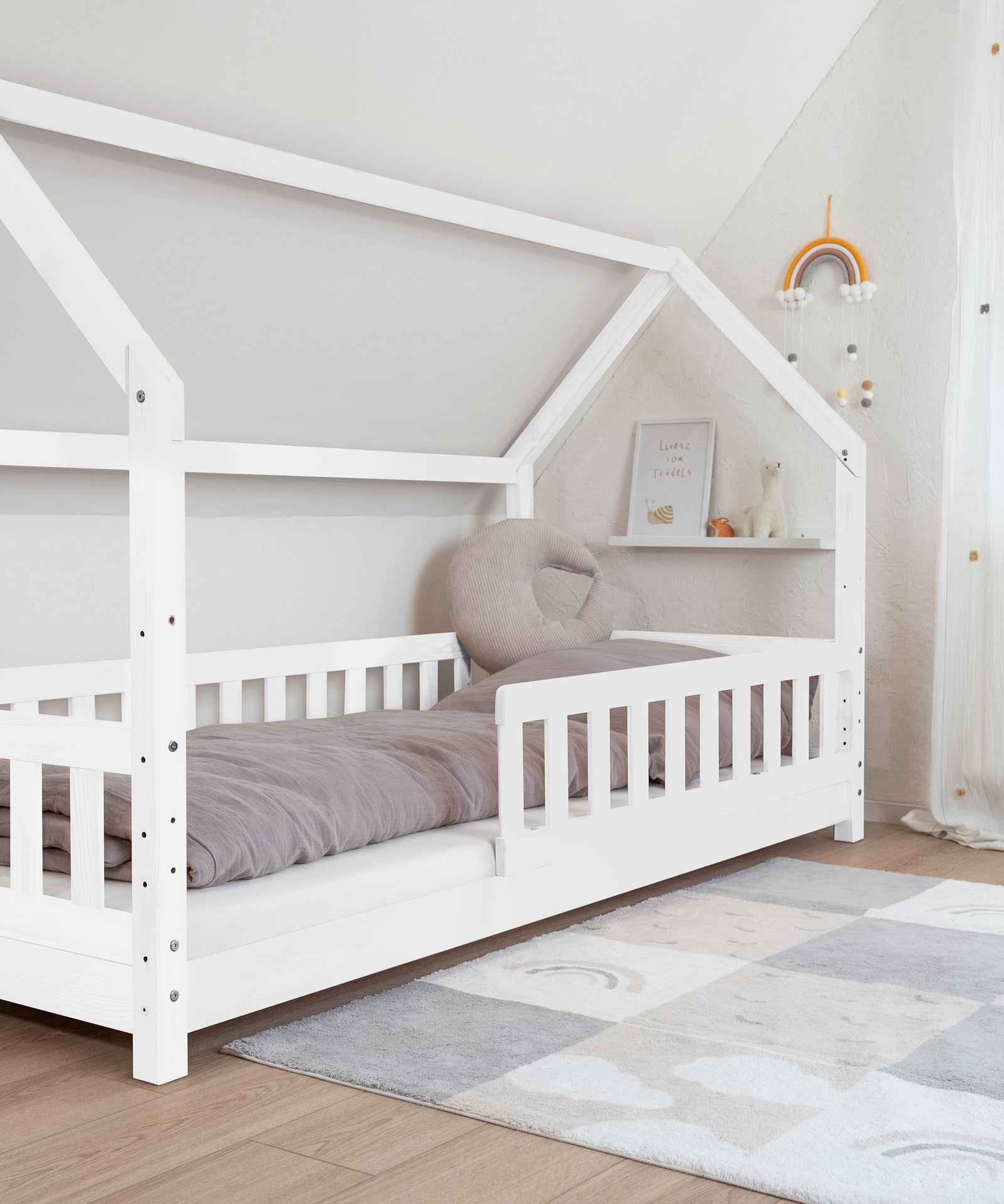 Hausbett Kiefer weiß, bodennah montiert.