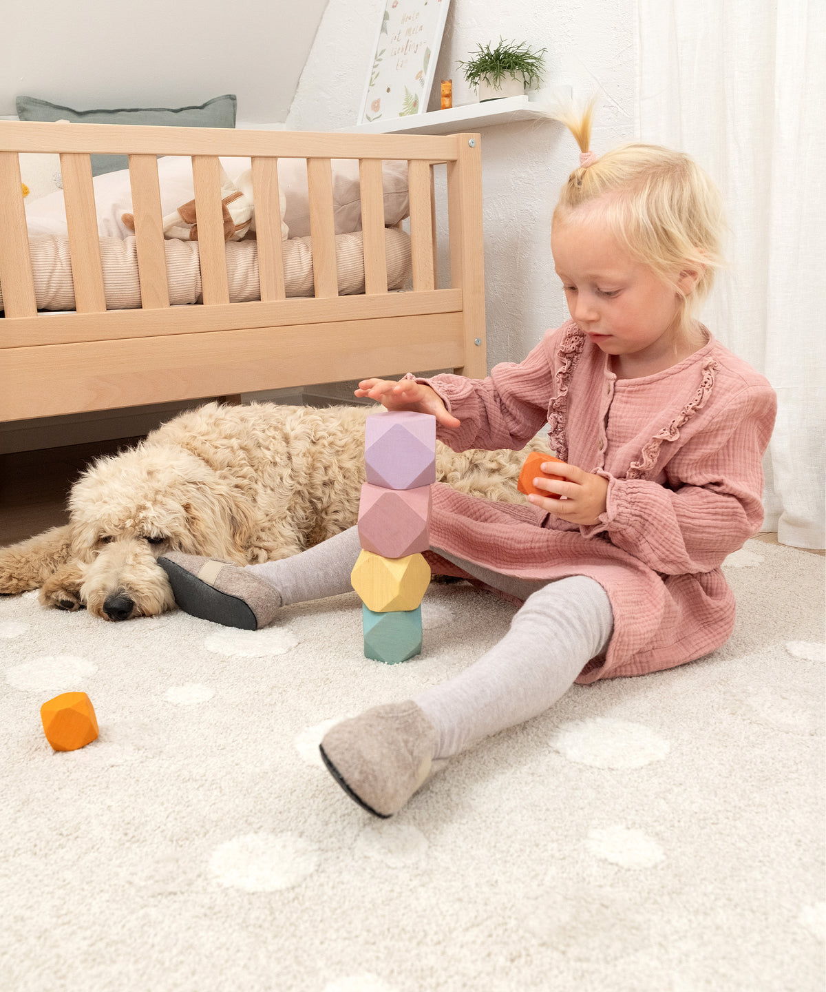 Mädchen spielt mit Kinder-Hausschuhen.