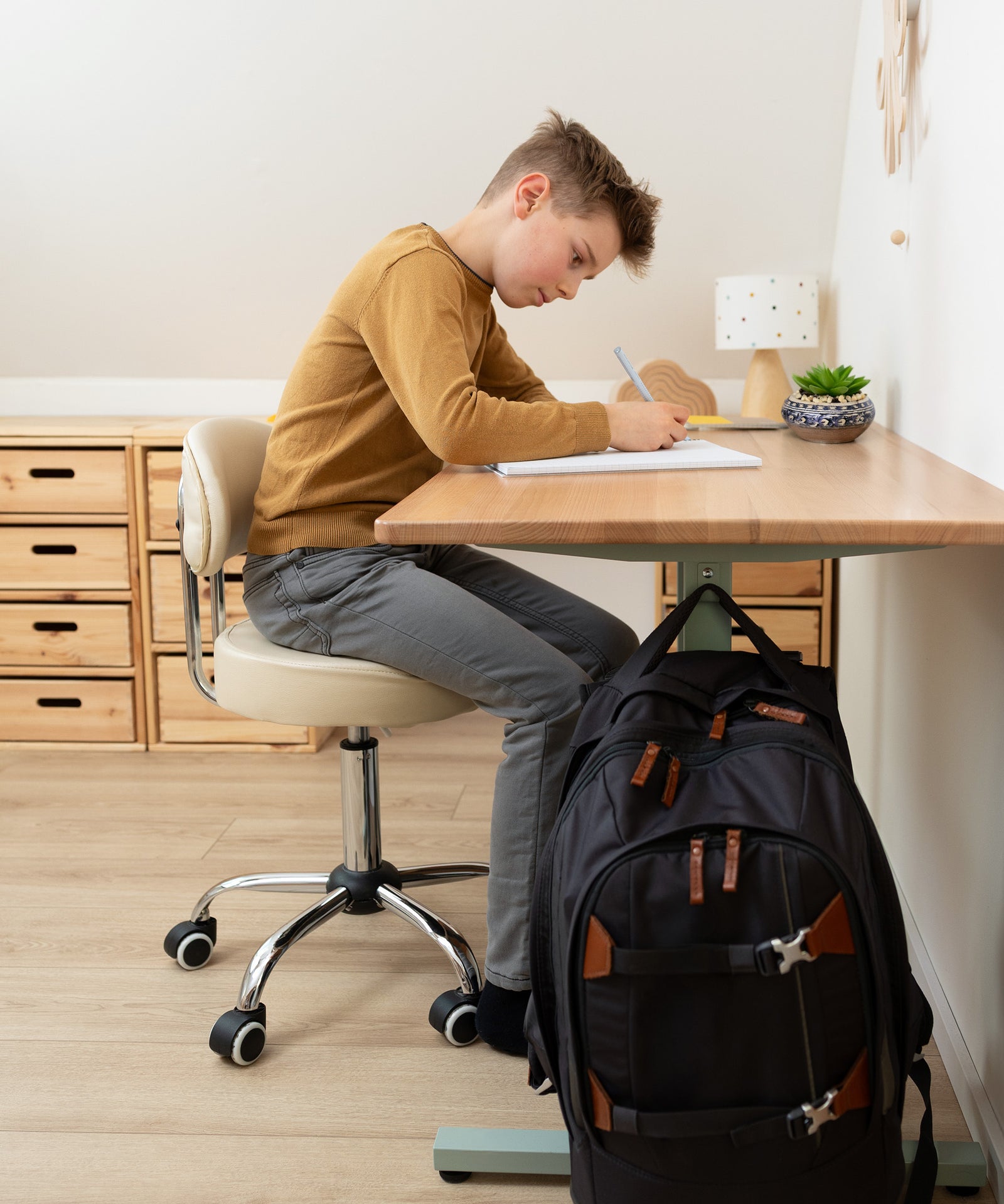 Kind erledigt Hausaufgaben und lernt am höhenverstellbaren Buchenholz-Schreibtisch.