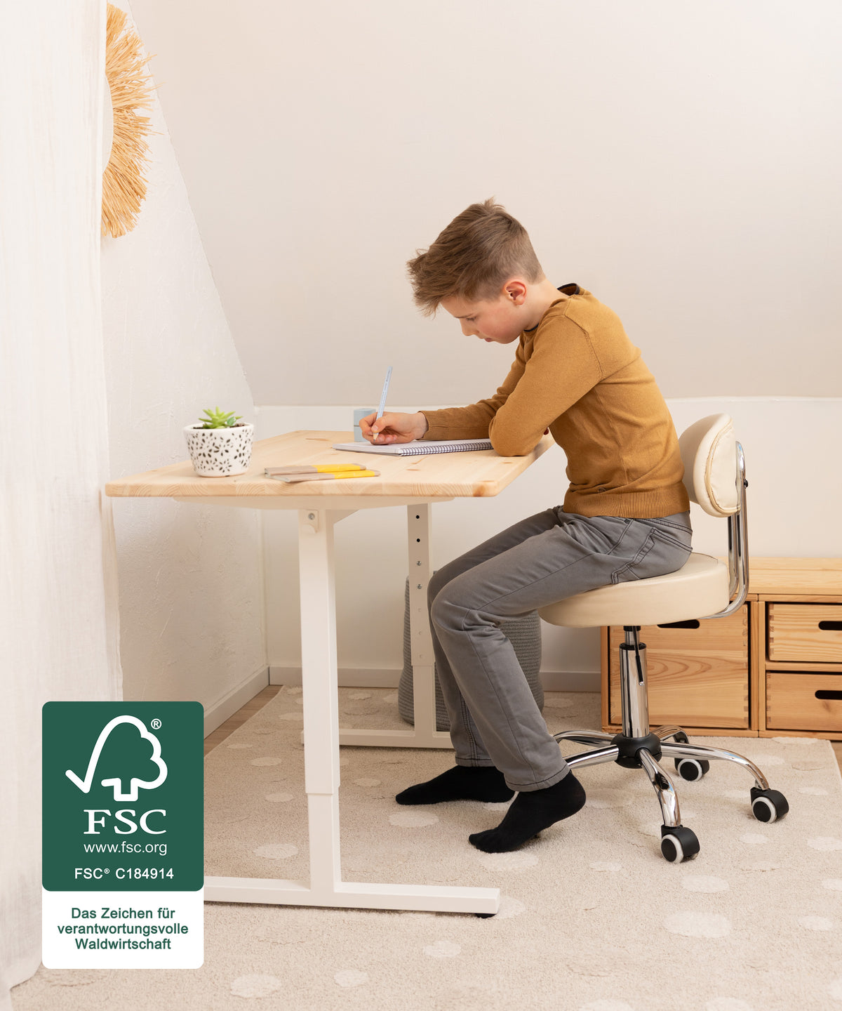 Von Schulstart bis Studium*Stufenweise höhenverstellbar: der Schreibtisch wächst dank einfacher Verstellung in 5-cm-Schritten (55-85 cm) mit.| Kind sitzt am Schreibtisch und macht Hausaufgaben.