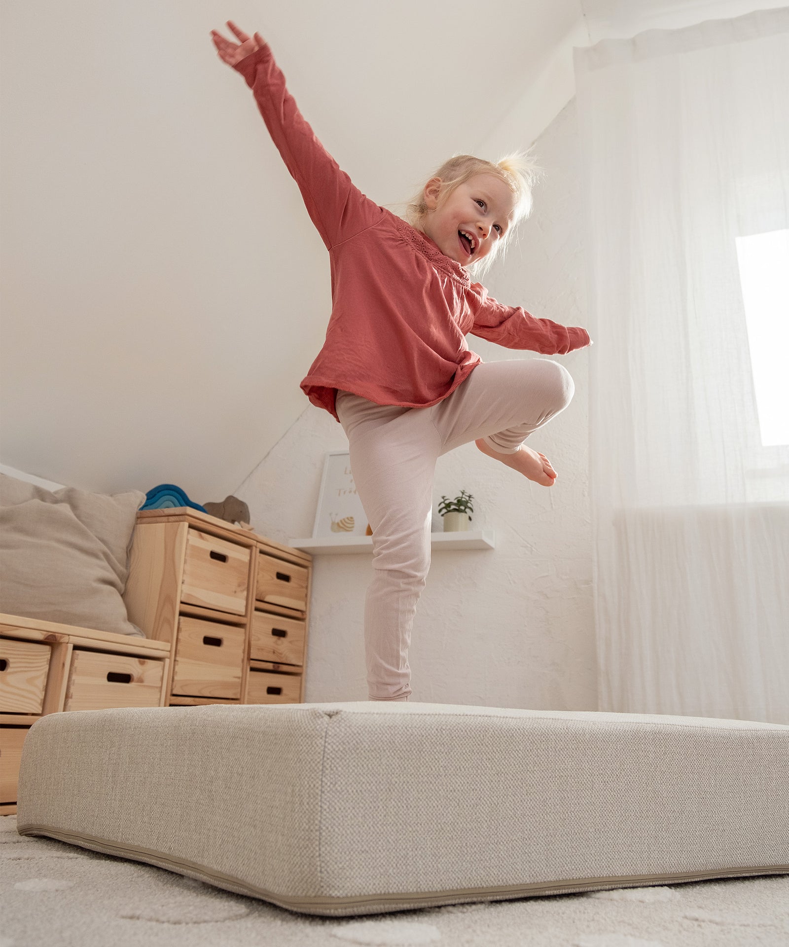 Kind spielt auf Hüpfpolster in Naturfarbe.
