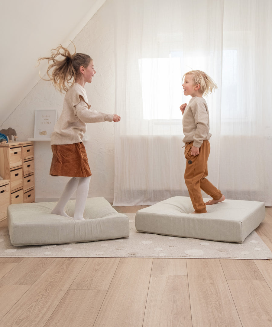 Kinder spielen auf Hüpfpolster.