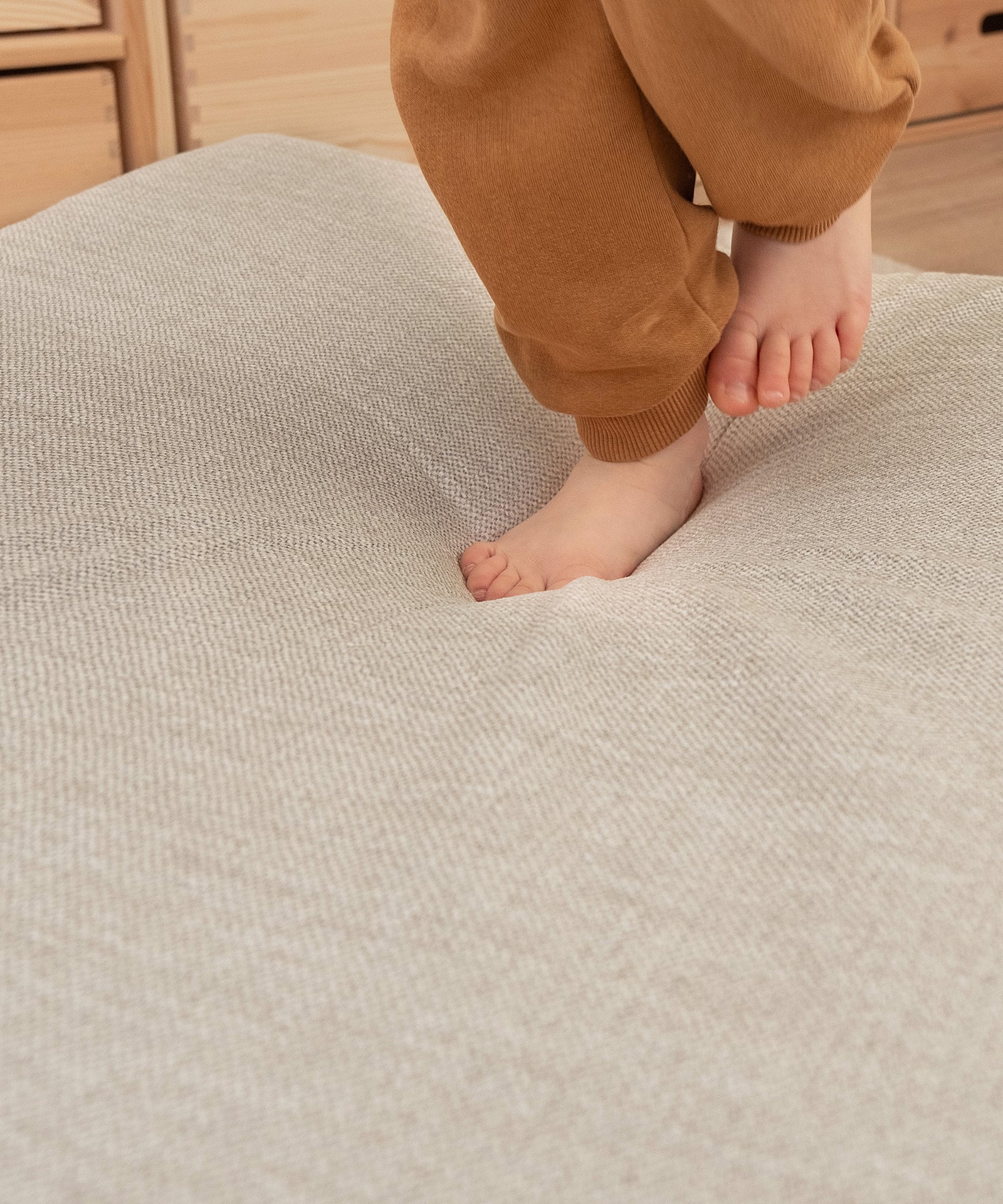 Kinderfüße auf Hüpfpolster in Natur beim Springen.