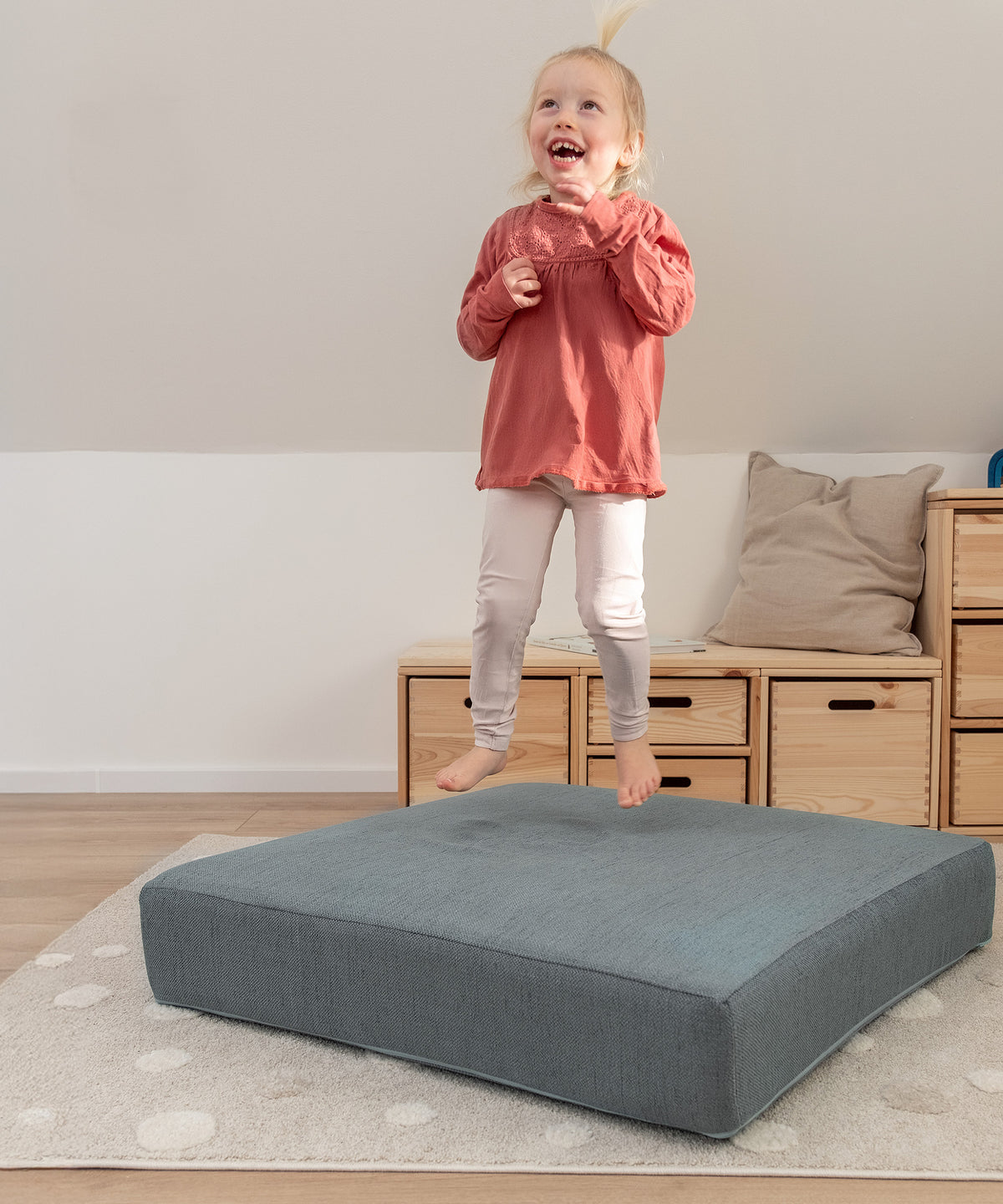 Made in Austria*Das Hüpfpolster wird in Österreich hergestellt. Alle Materialien sind nach OEKO-TEX® STANDARD 100 geprüft.| Kind springt auf dem Hüpfpolster Petrol.