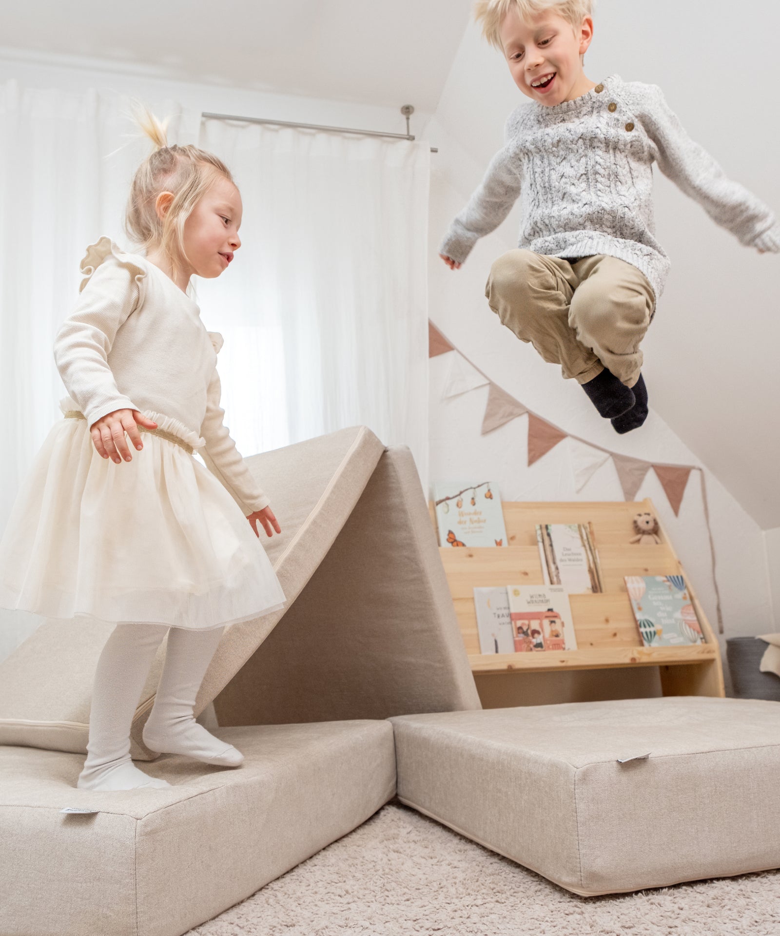 Integrierte Hüpfpolster*Ein Spielsofa, das mehr kann: Die integrierten Hüpfpolster ermöglichen ausgelassenes Springen und fördern spielerisch die Motorik.| Kinder springen auf den Hüpfpolster von dem  Spielsofa.