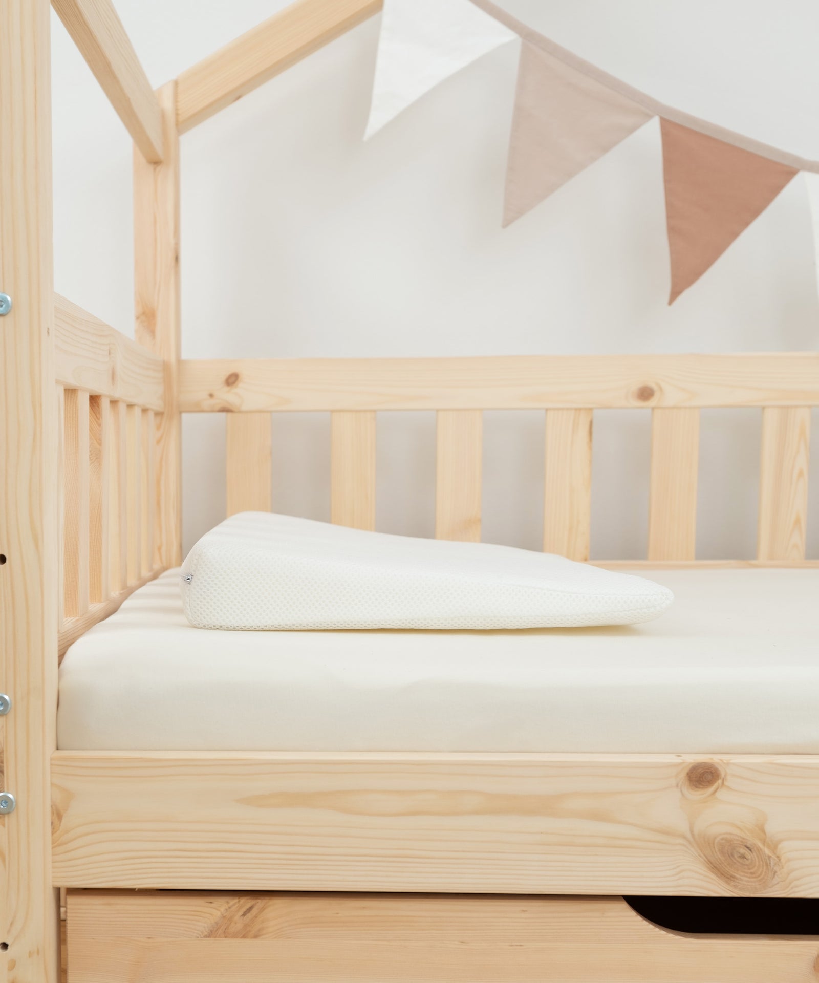 Vielfältig einsetzbar*Das Keilkissen bietet Neugeborenen und auch älteren Kindern optimalen Liegekomfort. Eltern können es zudem als Kniekissen nutzen.|Keilkissen liegt auf Matratze.