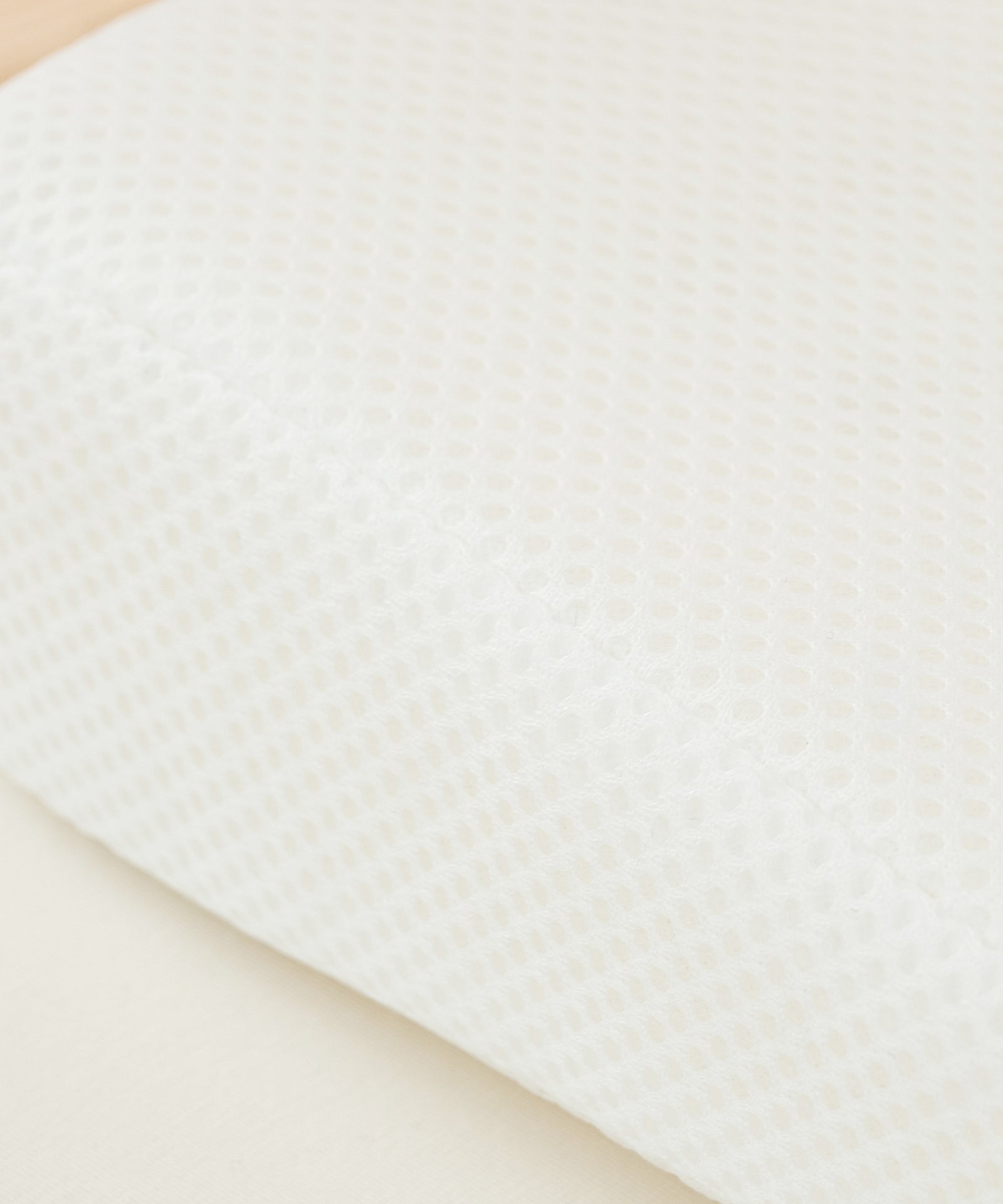 Kühl & hygienisch*Das hypoallergene Keilkissen (ca. 60× 38×7 cm) bleibt dank Belüftungslöchern und atmungsaktivem Meshbezug trocken und kühl.|Nahaufnahme Mesh-Bezug Keilkissen.