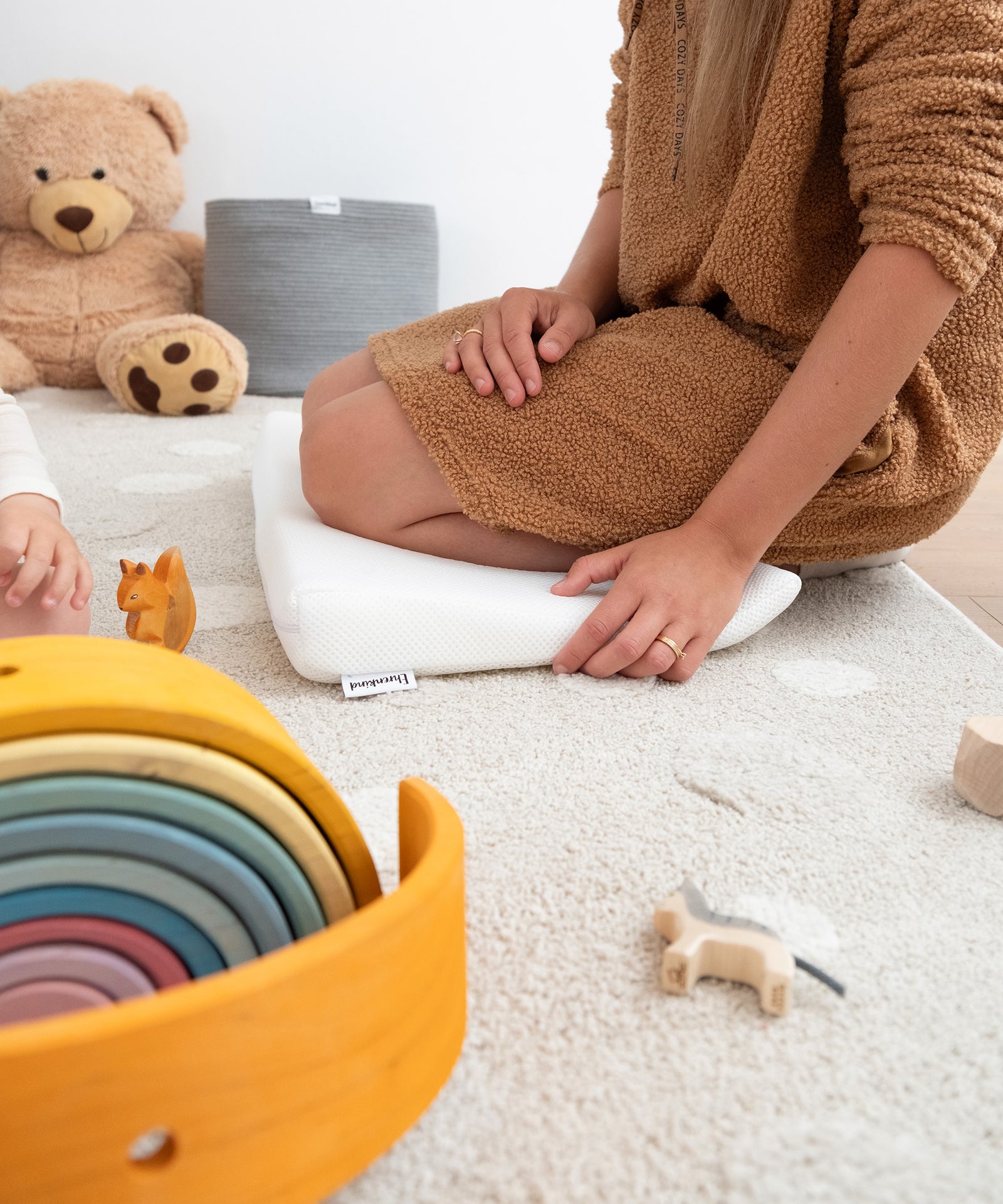 Praktisch als Kniekissen|Person kniet auf Keilkissen auf dem Boden.