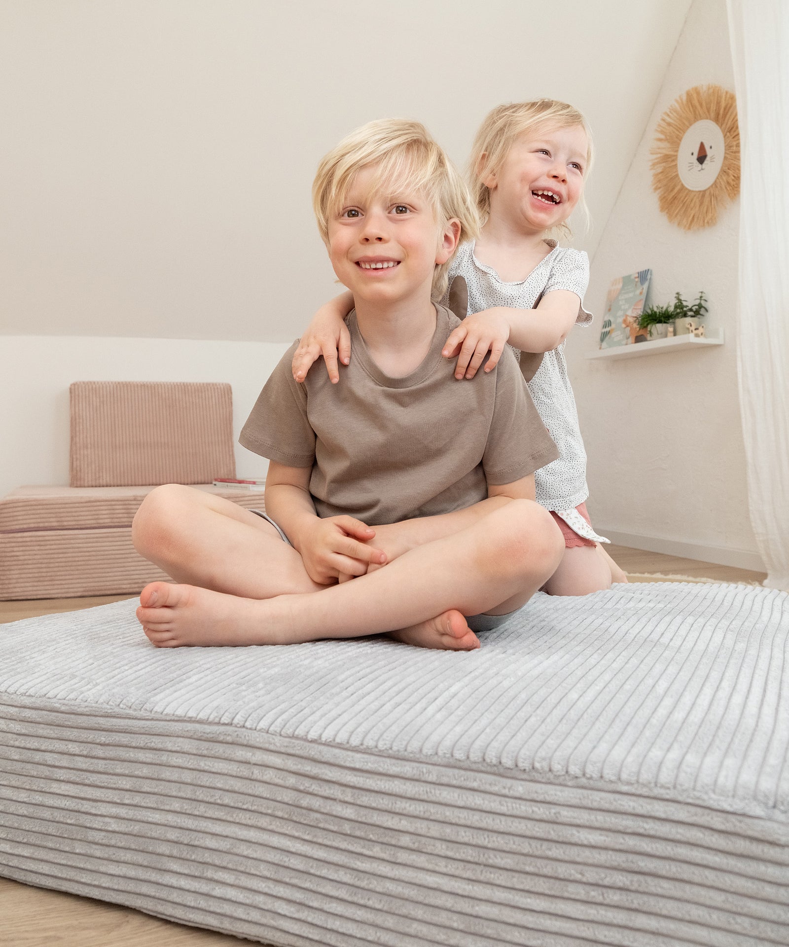 Kind sitzt auf Spielsofa-Hüpfpolster.