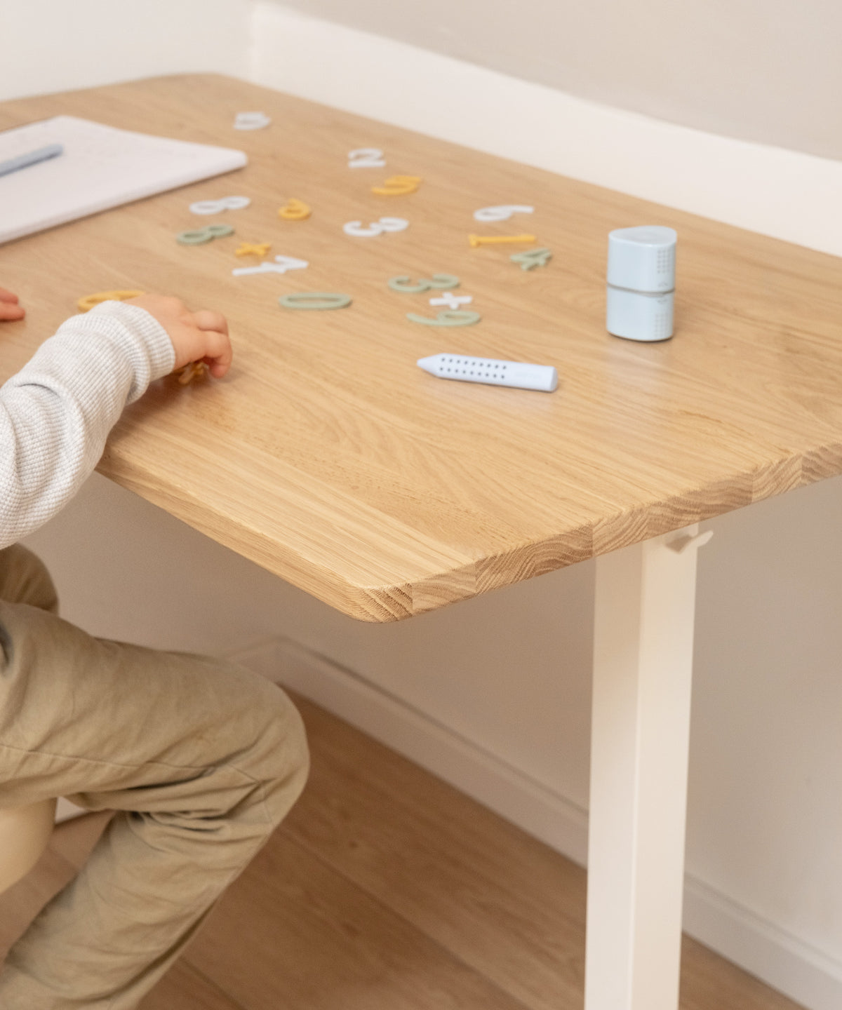 Kind sitzt am Schreibtisch aus Eiche und lernt.