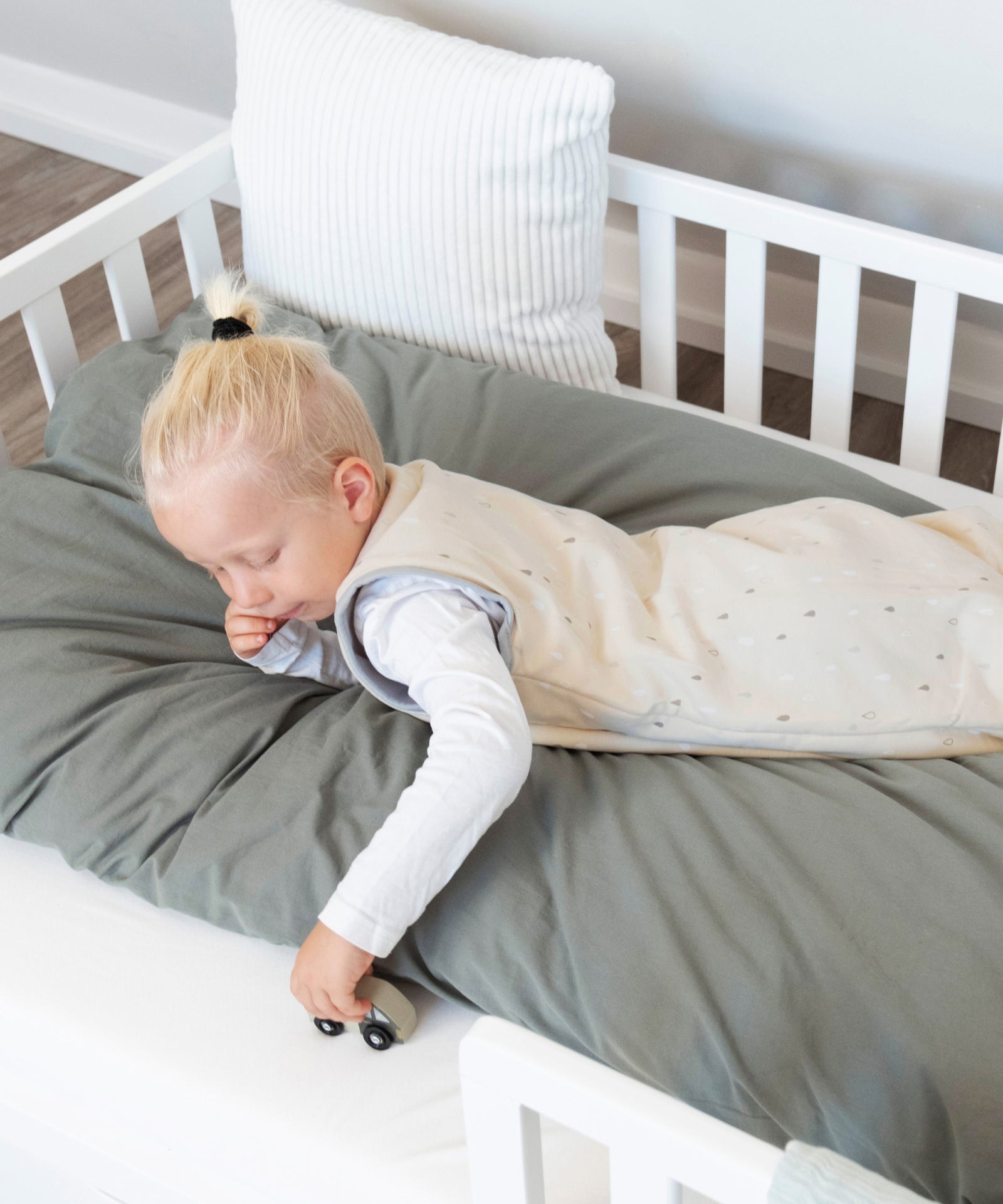 Kind spielt im Sommerschlafsack mit Beinen