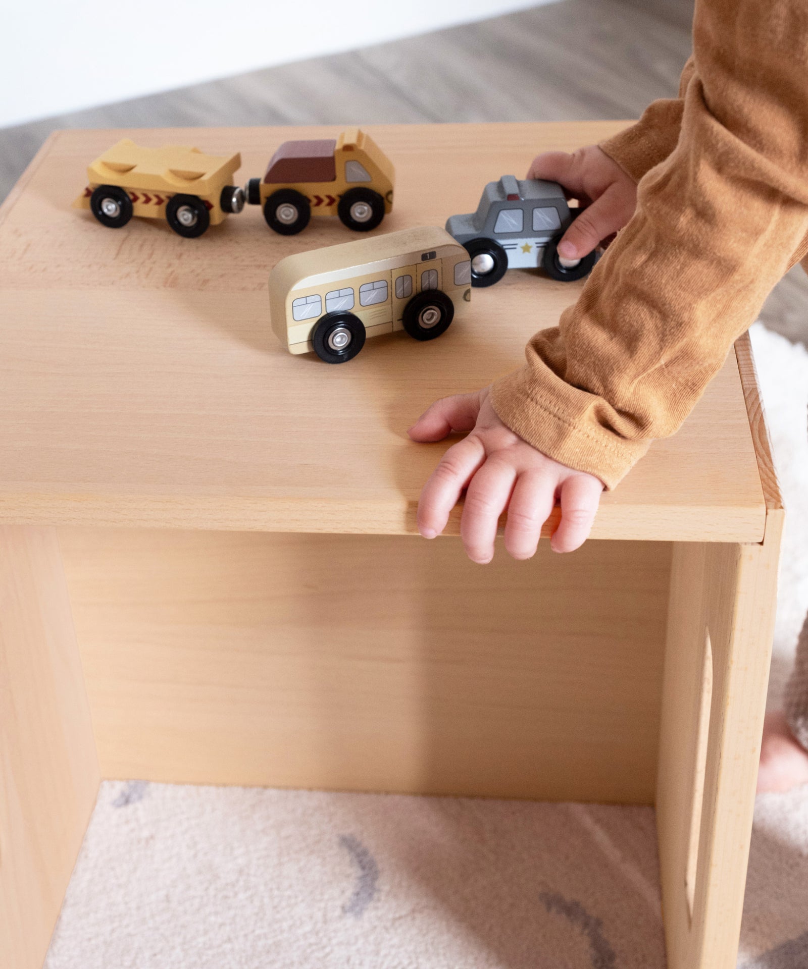 Kind spielt auf Hocker aus Buchenholz im Kinderzimmer.