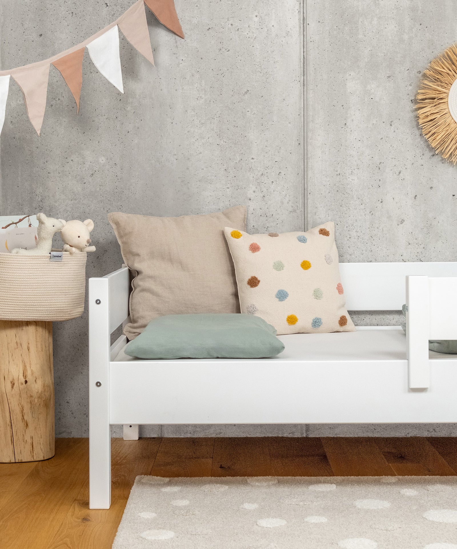 Ehrenkind Kinderbett in Weiß mit Kissen im Kinderzimmer.