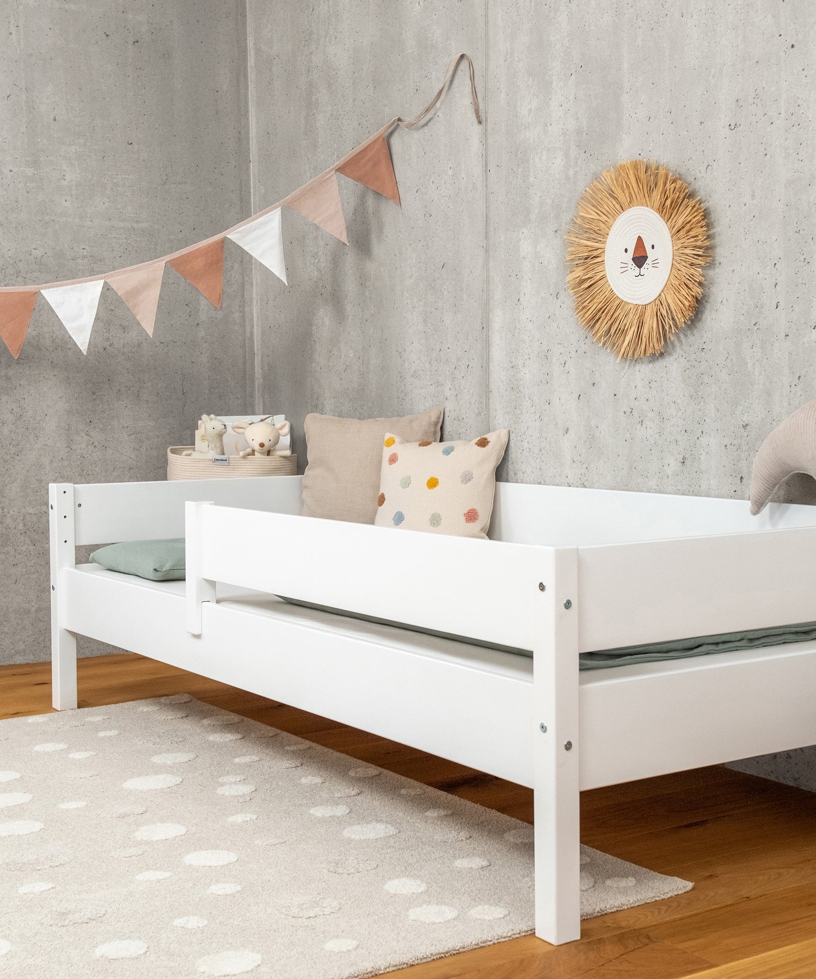 Ehrenkind Kinderbett weiß an Wand mit Deko.