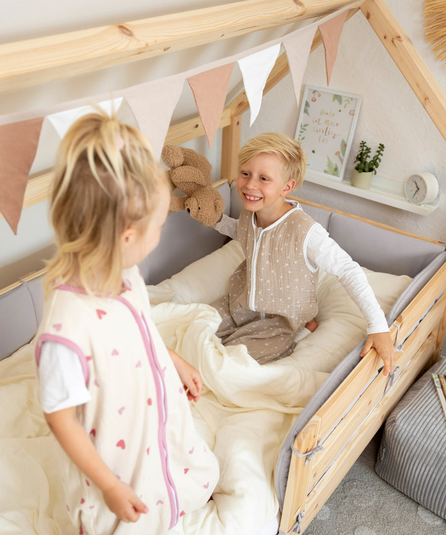 Gepolsterte Bettumrandung im Kinderbett begleitet Kinder beim Spielen und Kuscheln