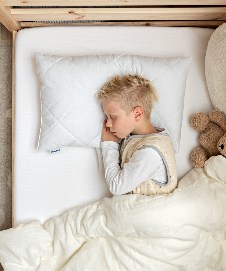 Kind schläft auf dem Kinderkissen in der Größe 60×40 cm.