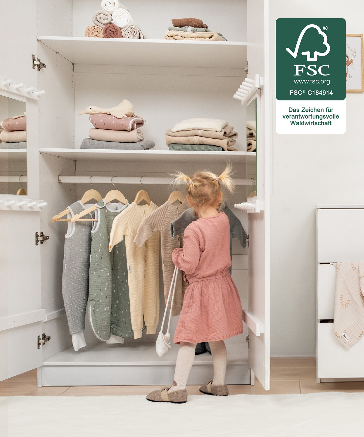 Für kleine Hände gemacht*Die kindgerechte Höhe ermöglicht selbstständiges Anziehen und Aufräumen - unterstützt spielerisch die Entwicklung im Alltag.| Mädchen räumt selbstständig die Kleidung in den Kleiderschrank.