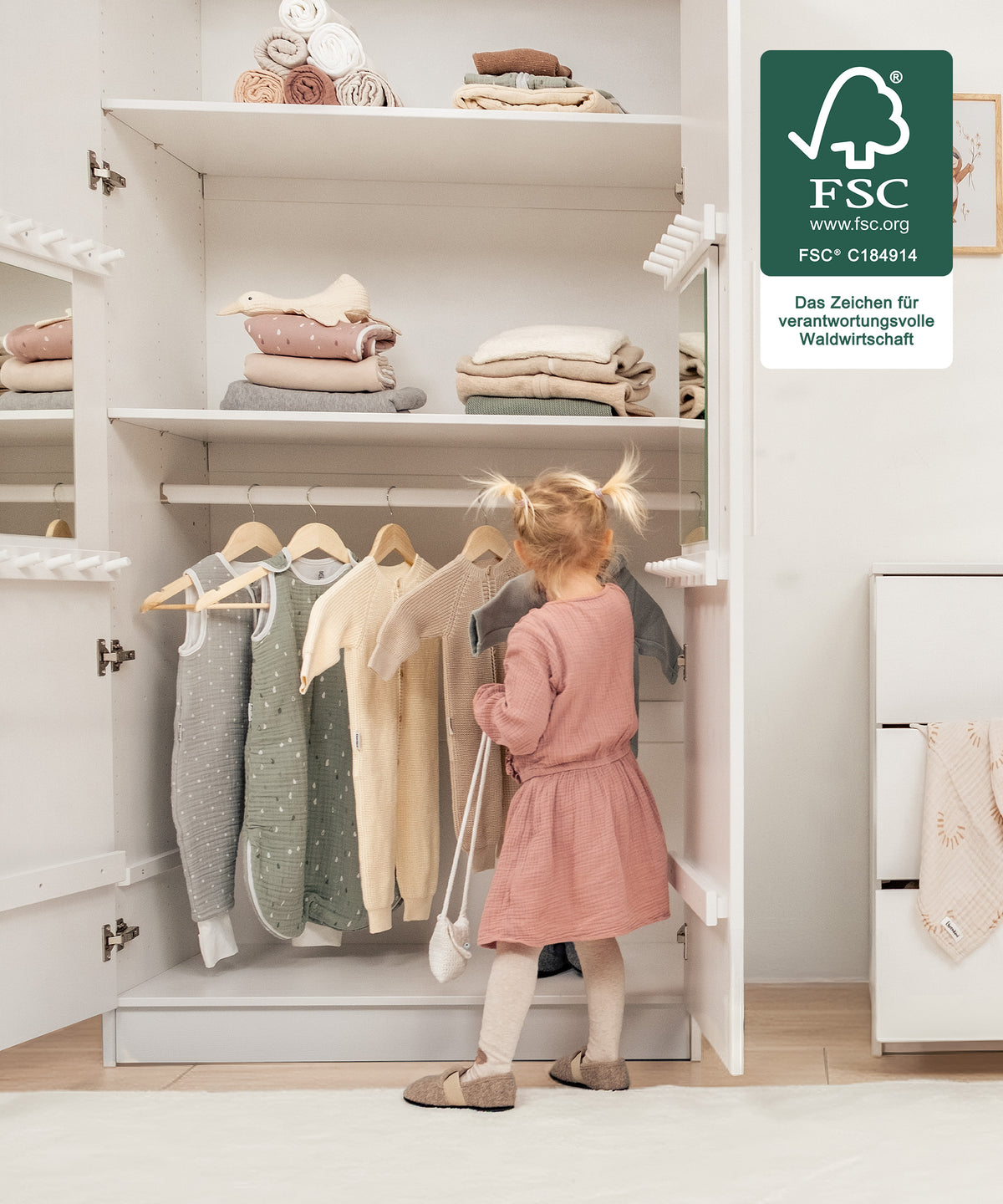 Für kleine Hände gemacht*Die kindgerechte Höhe ermöglicht selbstständiges Anziehen und Aufräumen - unterstützt spielerisch die Entwicklung im Alltag.| Mädchen räumt selbstständig die Kleidung in den Kleiderschrank.